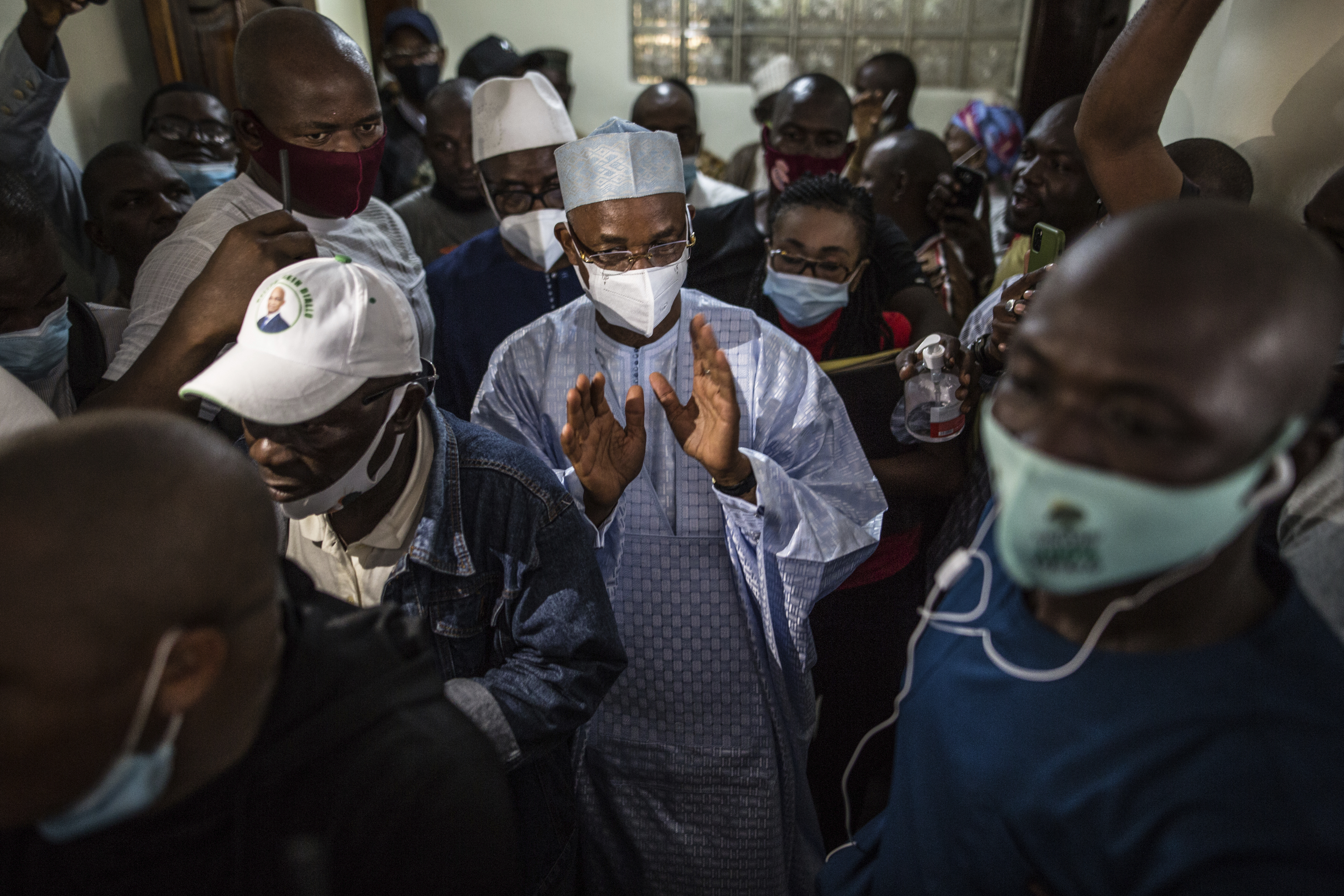 Guinean opposition leader Cellou Dalein Diallo, centre, walks with supporters at his headquarters in Conakry, Guinea