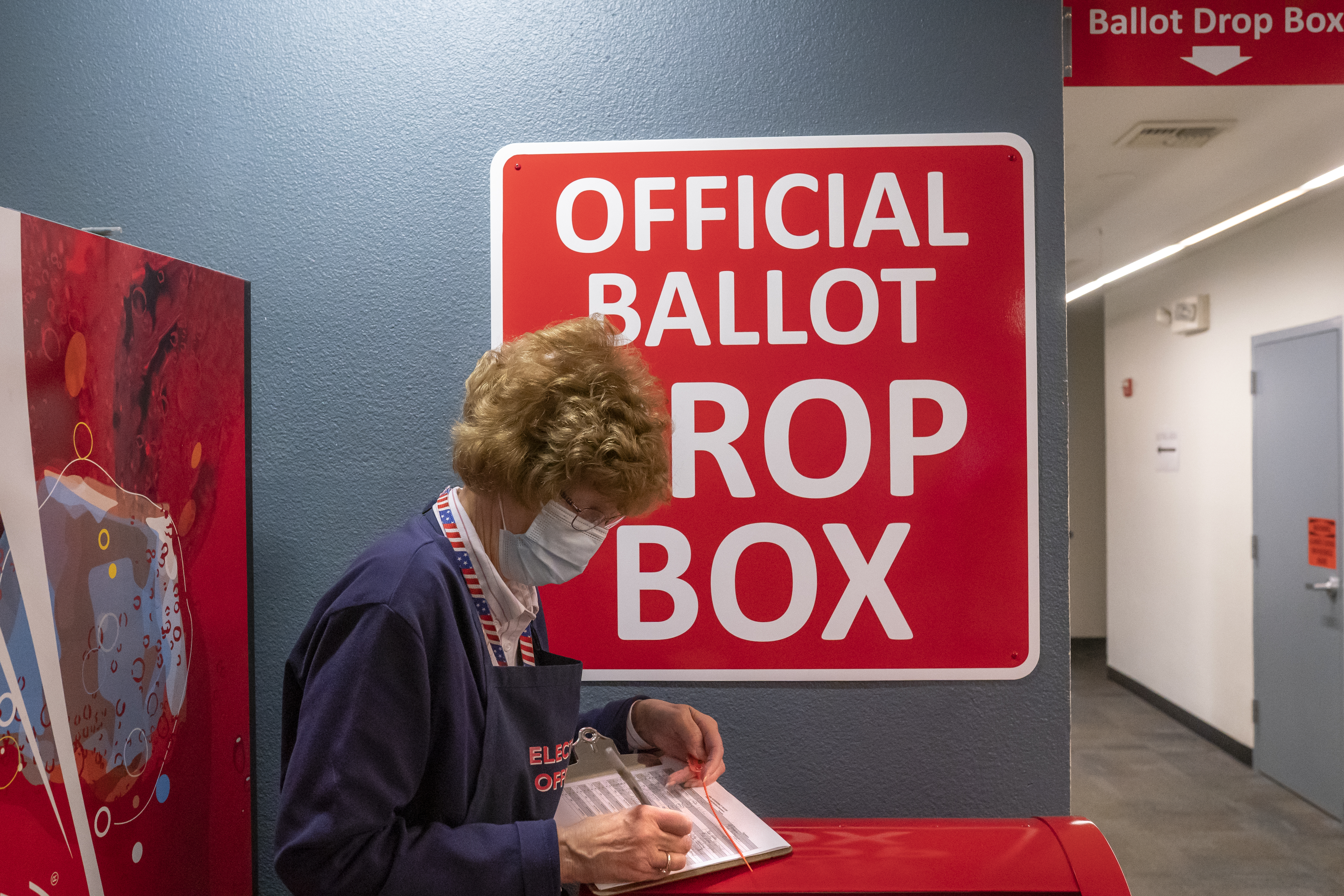 An election worker makes a record of a ballot pickup on November 3, 2020 in Vancouver, Washington. After a record-breaking early voting turnout, Americans head to the polls on the last day to choose between incumbent President Donald Trump and Democratic nominee Joe Biden in the 2020 presidential election [Nathan Howard/Getty Images/AFP] (AFP)