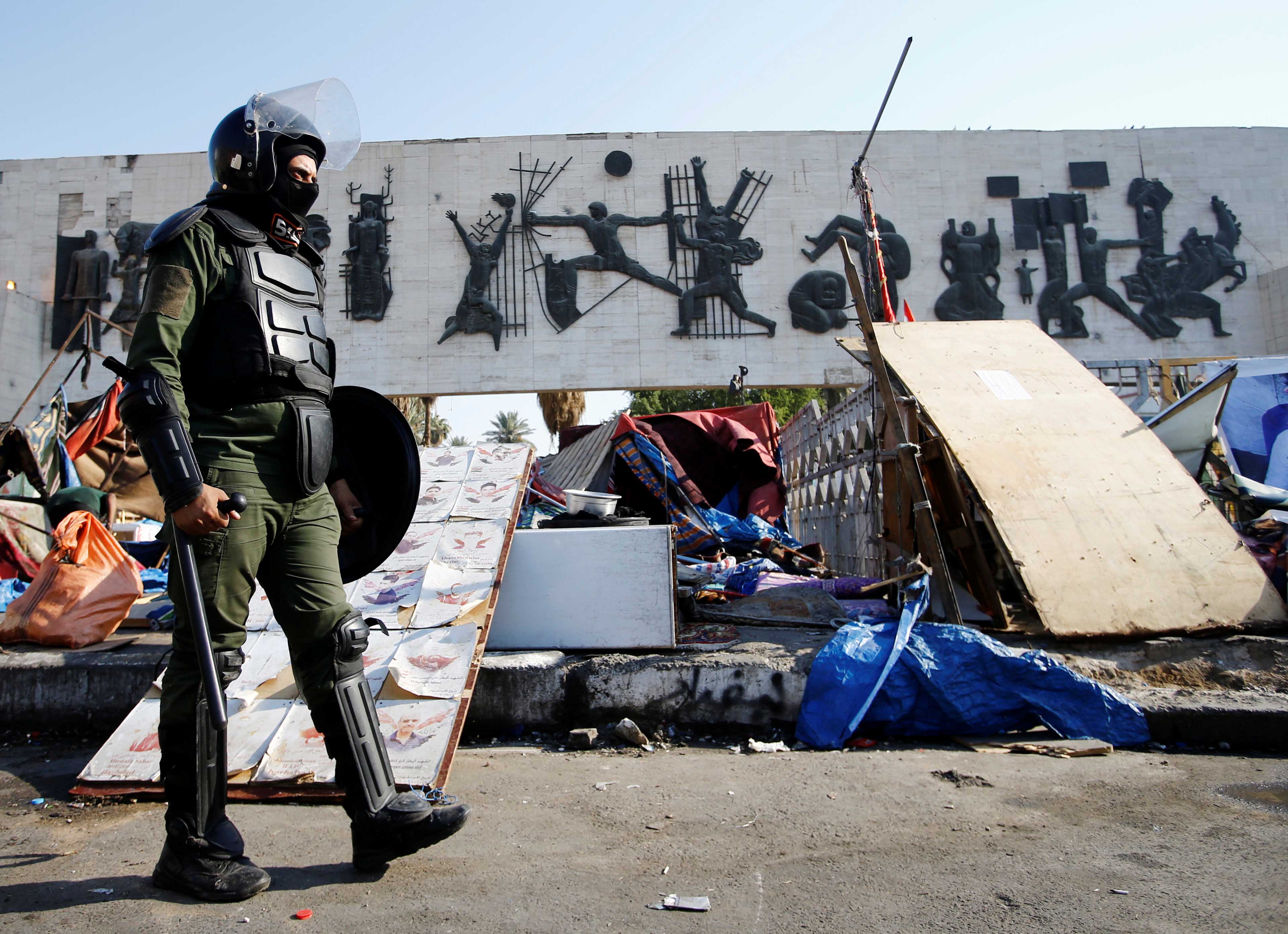 A member of Iraqi security forces is seen as they remove the tents set up on Tahrir square and reopen the Jumhuriya bridge in Baghdad on October 31, 2020 [Reuters/Khaled Al-Mousily]