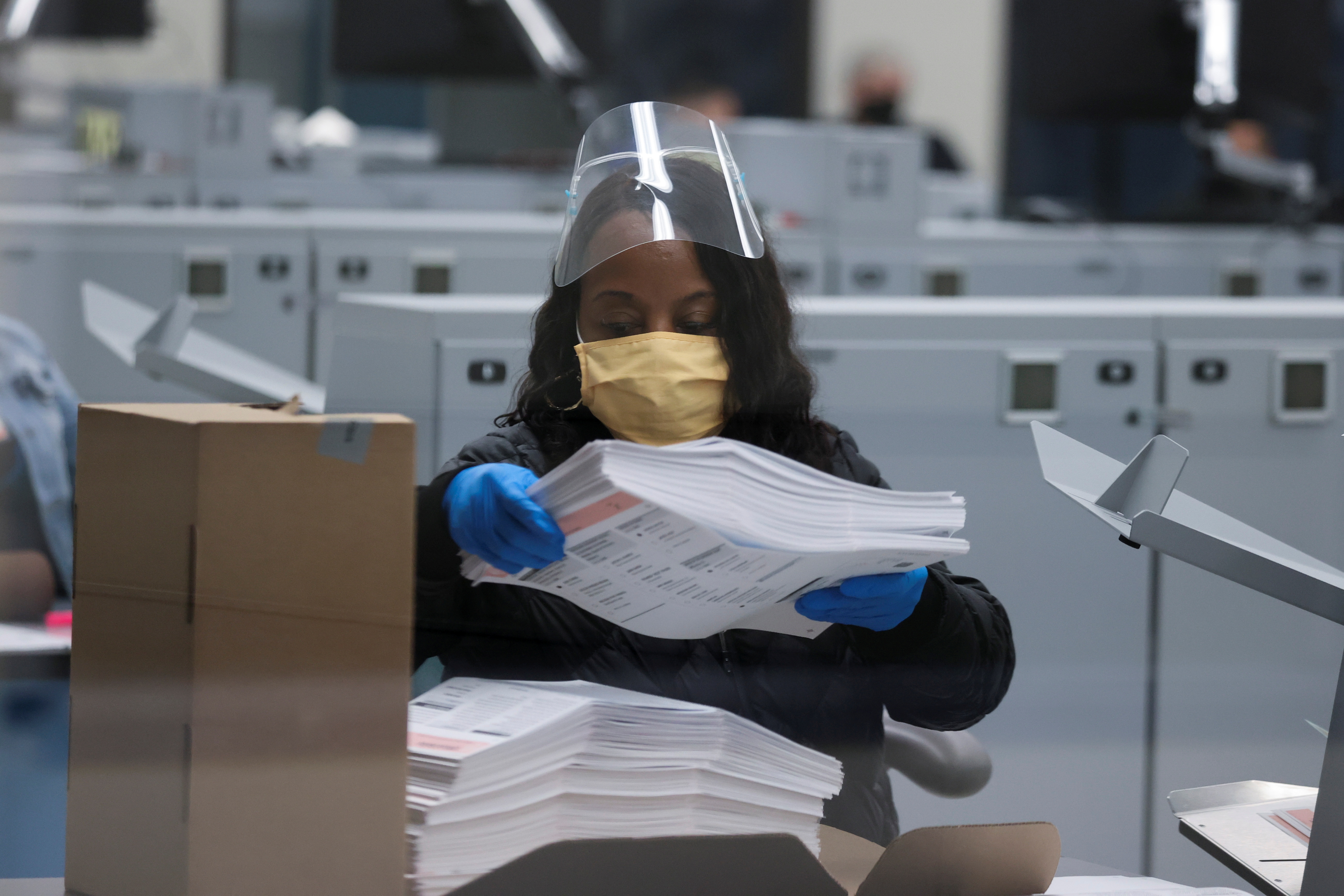 A person sorts postal ballots following the 2020 U.S. presidential election