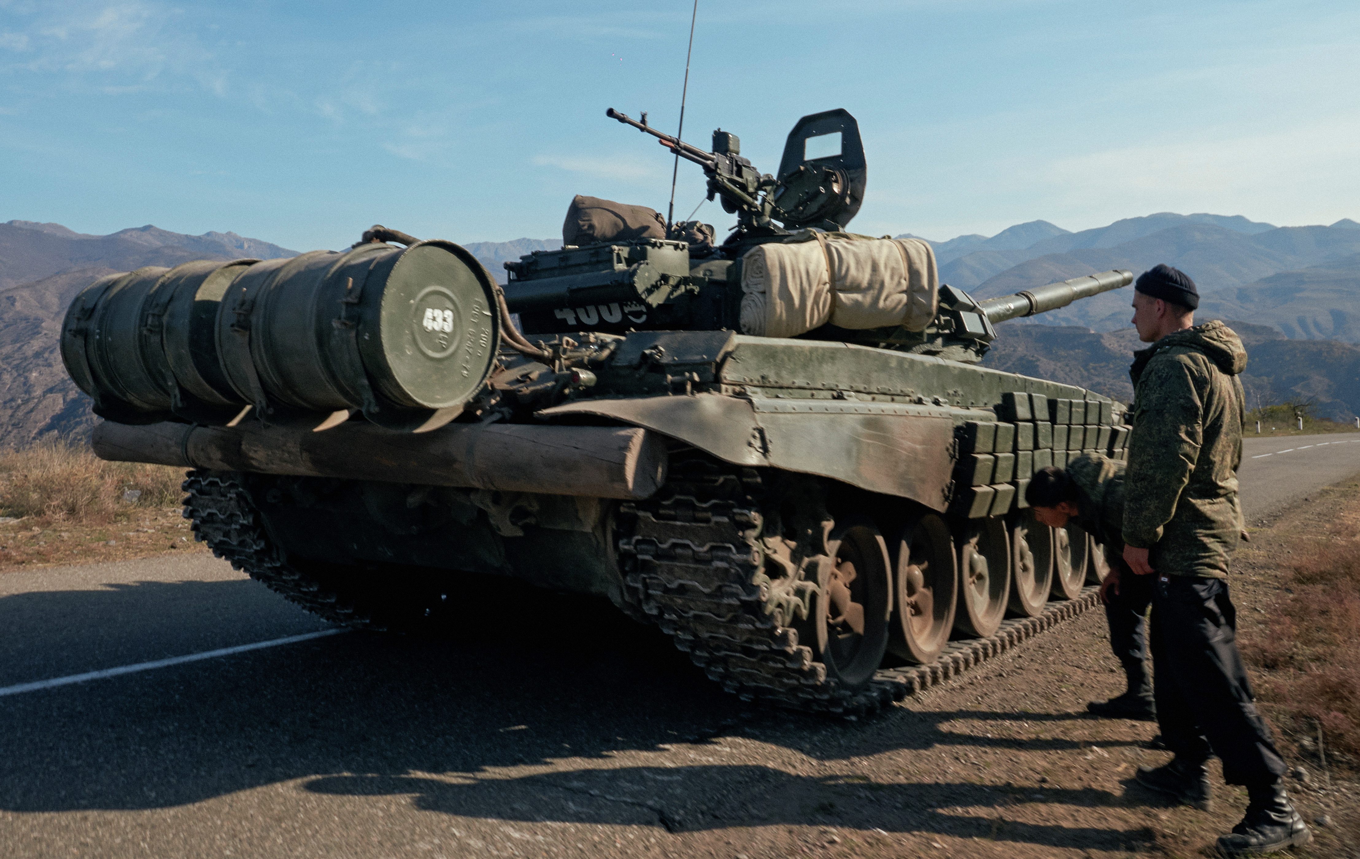 Service members of the Russian peacekeeping troops stand next to a tank near the border with Armenia [Francesco Brembati/Reuters]
