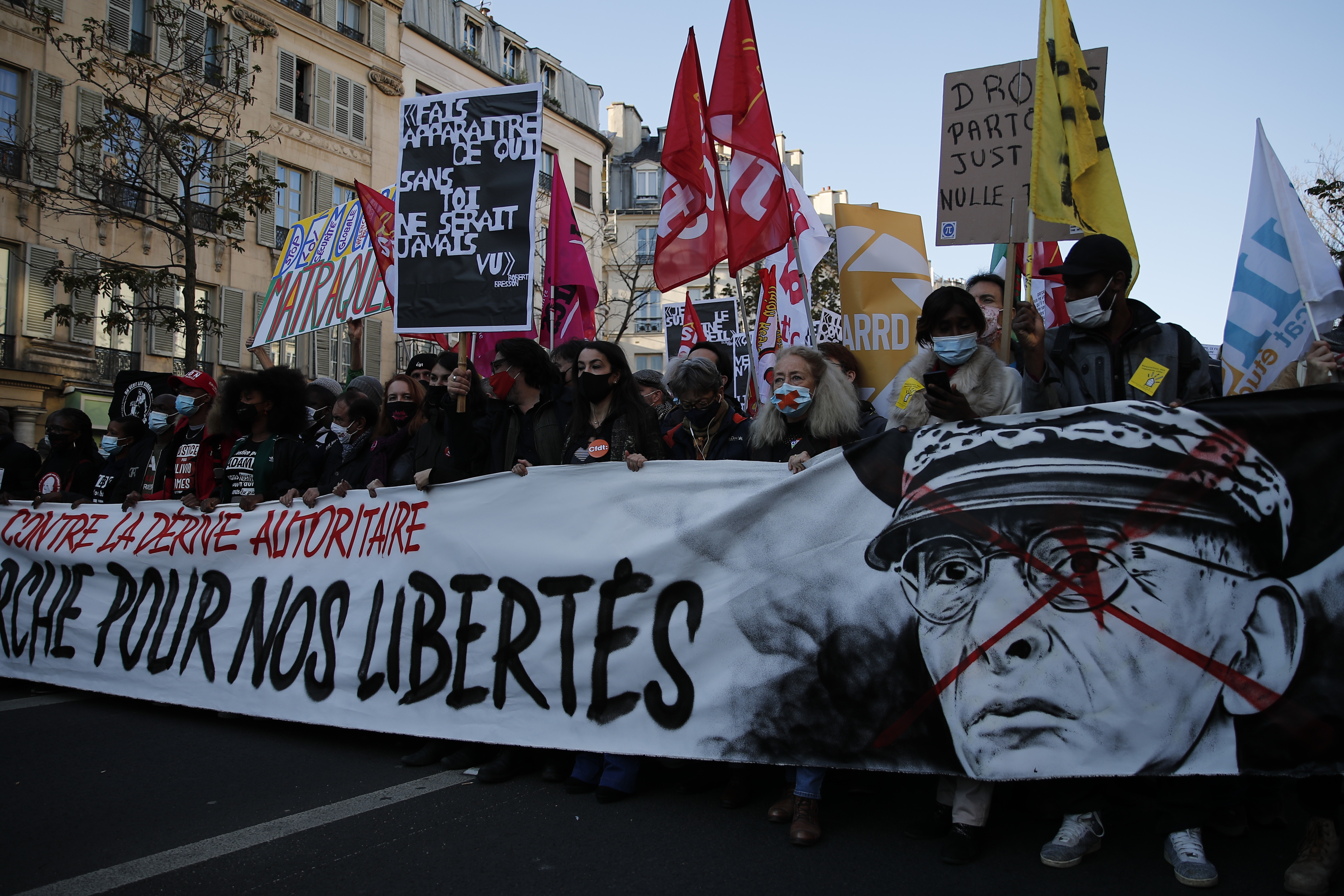 Protesters hold a banner that reads "For our freedom" during a demonstration against the proposed security law that would restrict sharing images of police, Nov 28, 2020 in Paris, France [AP Photo/Francois Mori]