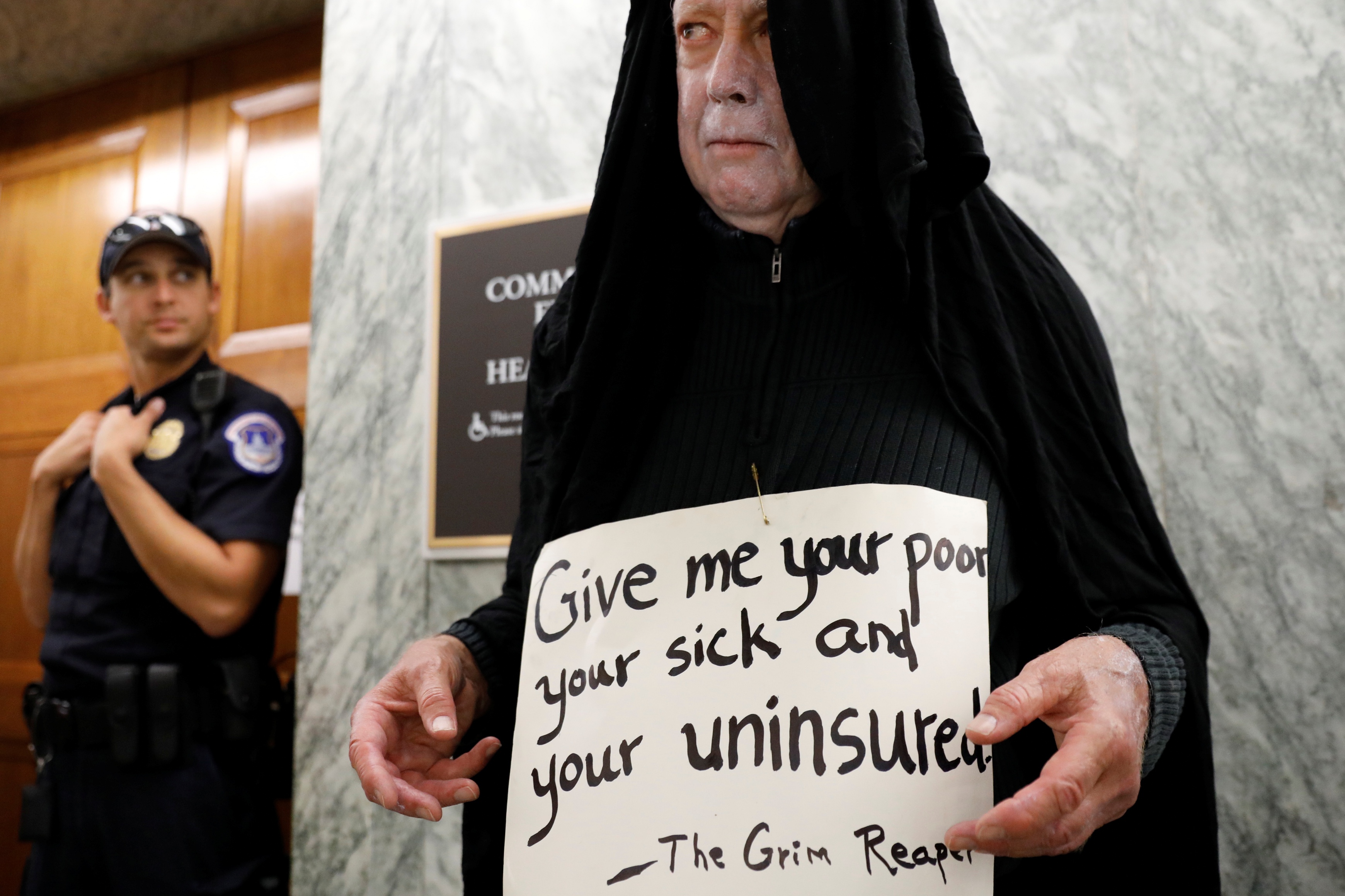 In a 2017 photo, a protester dressed as the grim reaper stands outside the Senate Finance Committee hearing room ahead of a hearing on an effort to repeal Obamacare [File: Reuters]