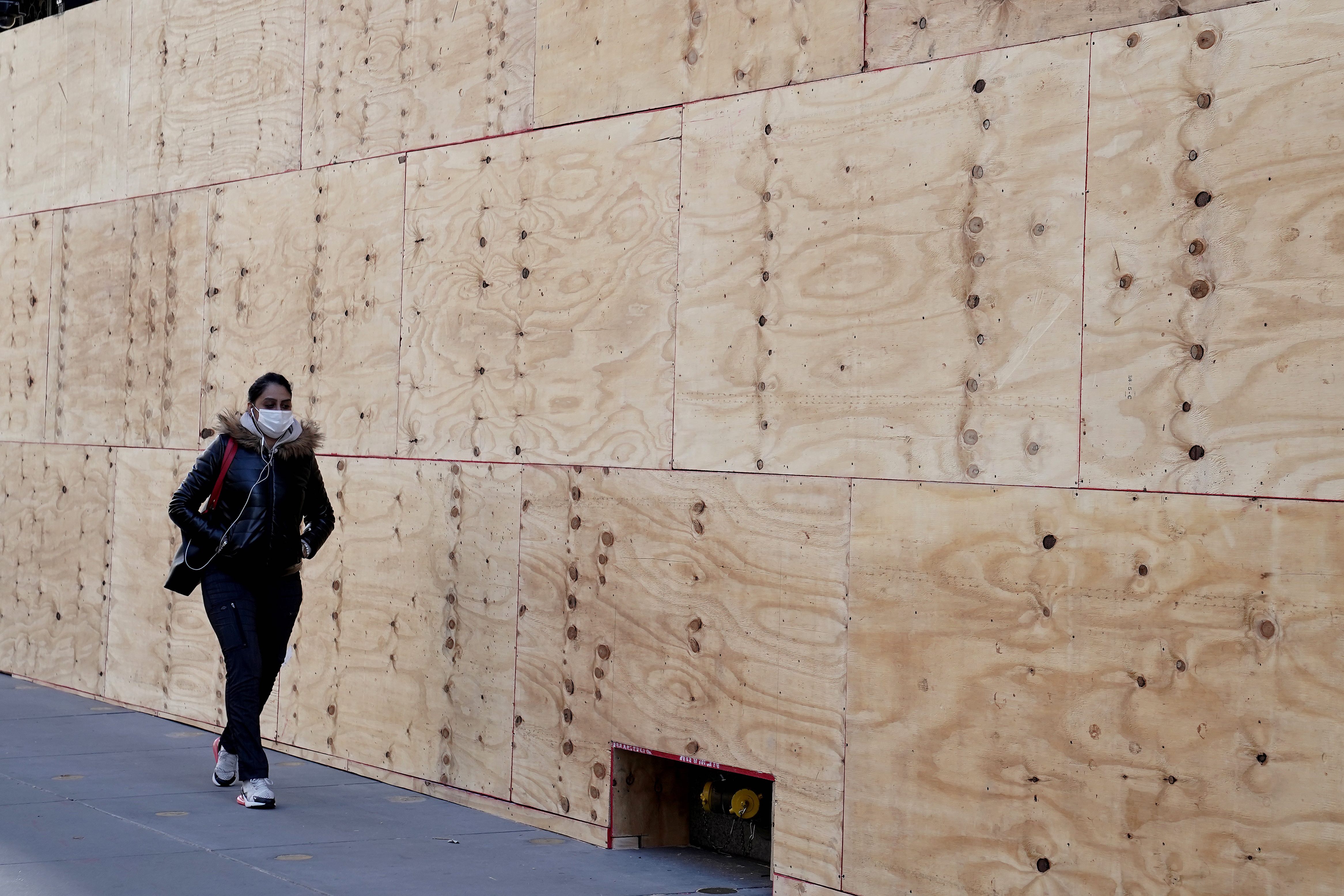 A person walks past the boarded-up Saks Fifth Ave store in anticipation of tomorrow’s elections in the Manhattan borough of New York City, New York, the United States