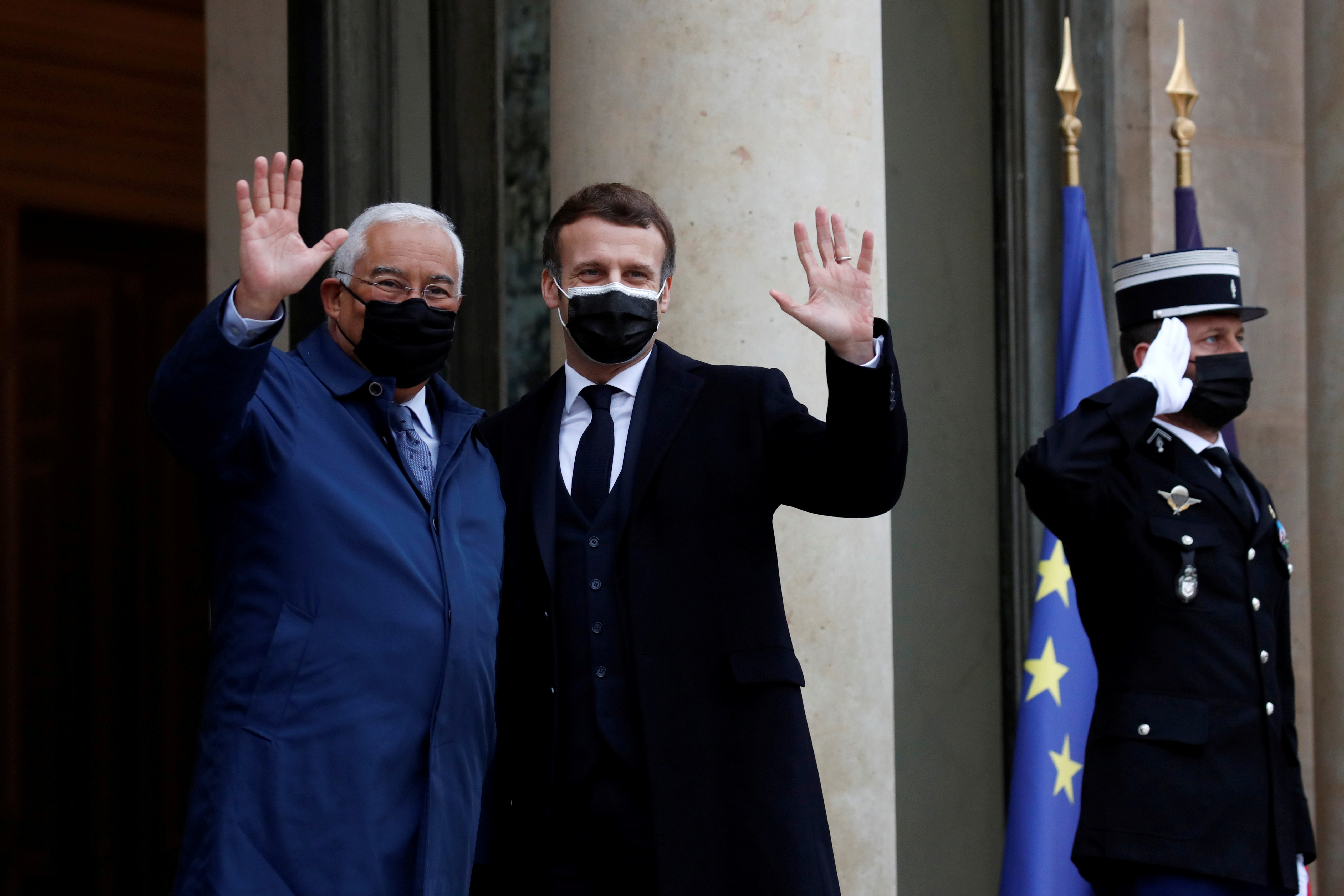 French President Emmanuel Macron and Portugal’s Prime Minister Antonio Costa wave to journalists as they enter the Elysee Palace in Paris, France