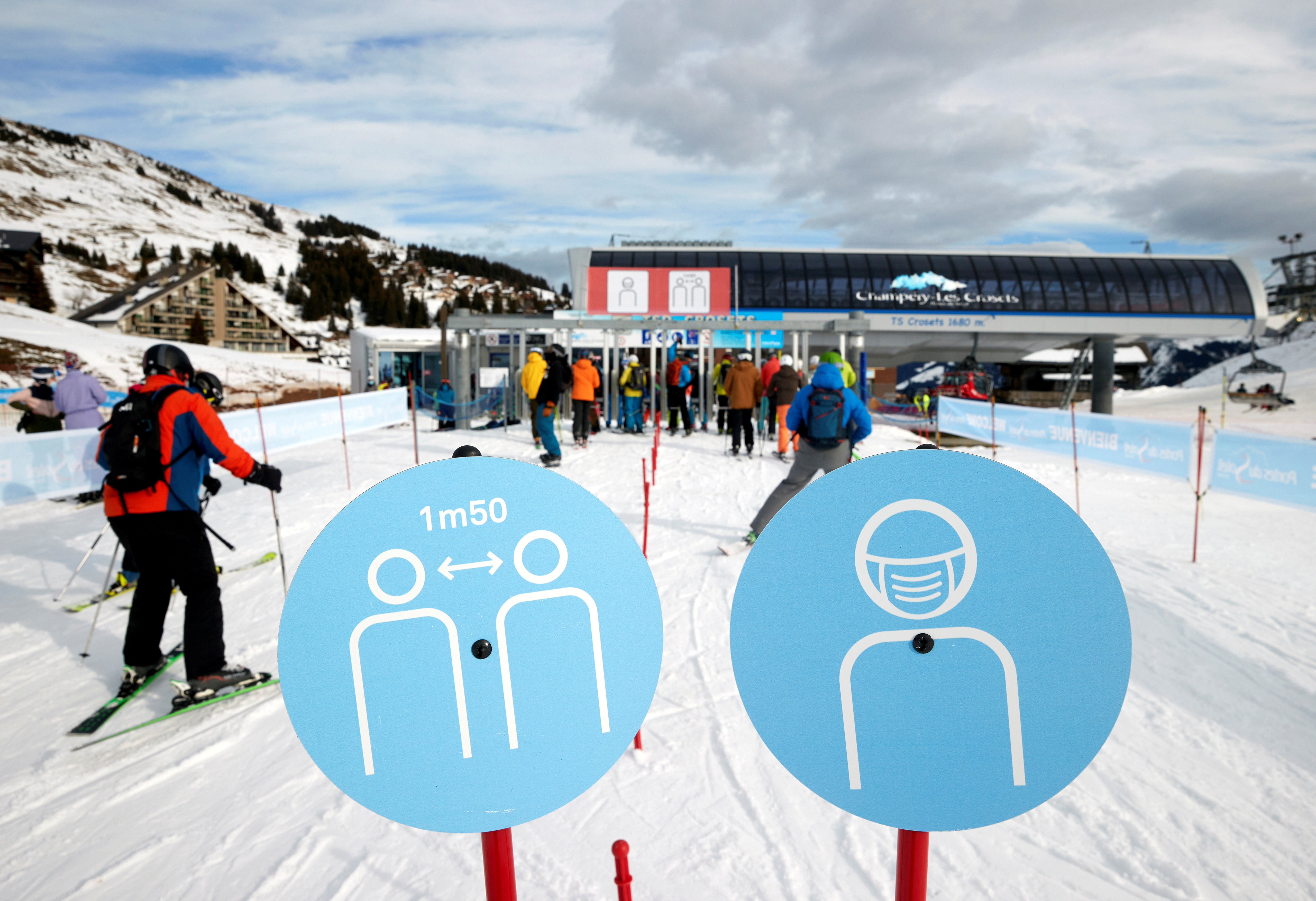 Skiers pass the restriction signs to line up at the chairlift at Les Portes du Soleil ski resort during the global outbreak of the coronavirus disease in Les Crosets, Switzerland