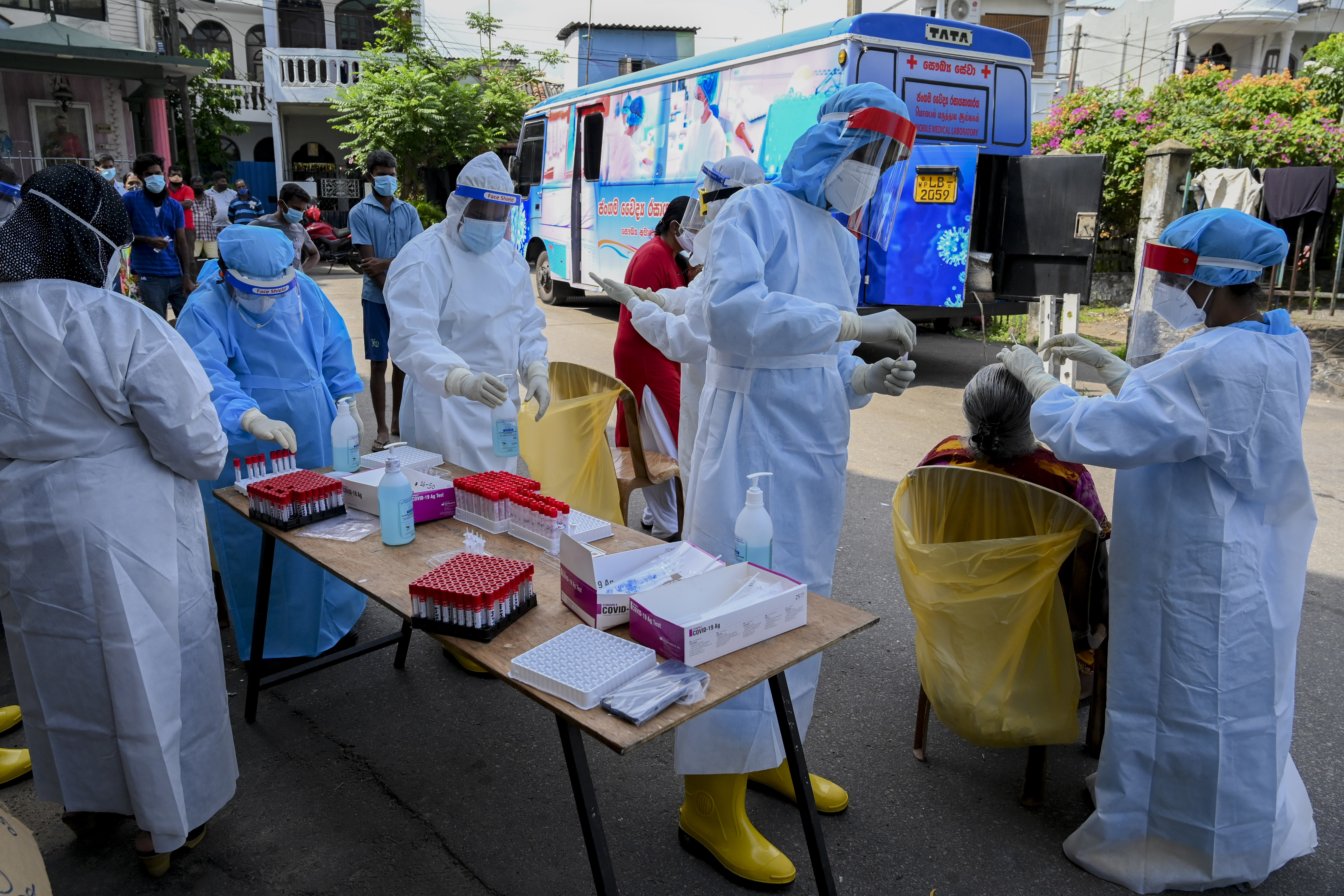 Health workers collect a swab sample from a resident to test for the coronavirus in Colombo on January 4, 2021. [Ishara Kodikara /AFP]
