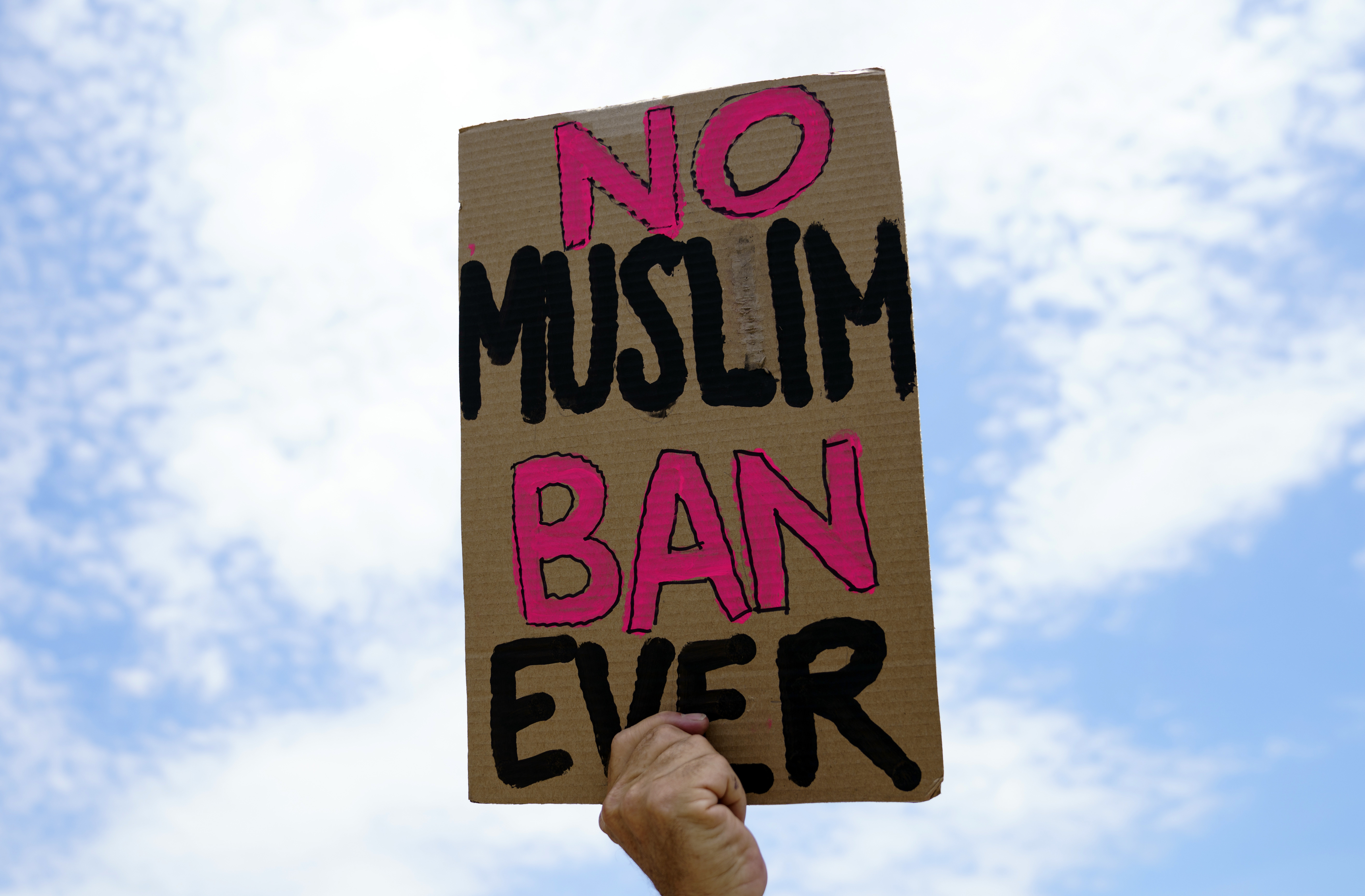Demonstrators protest against the Supreme Court ruling upholding former president Donald Trump's travel ban in Washington, DC [File: Carolyn Kaster/AP]