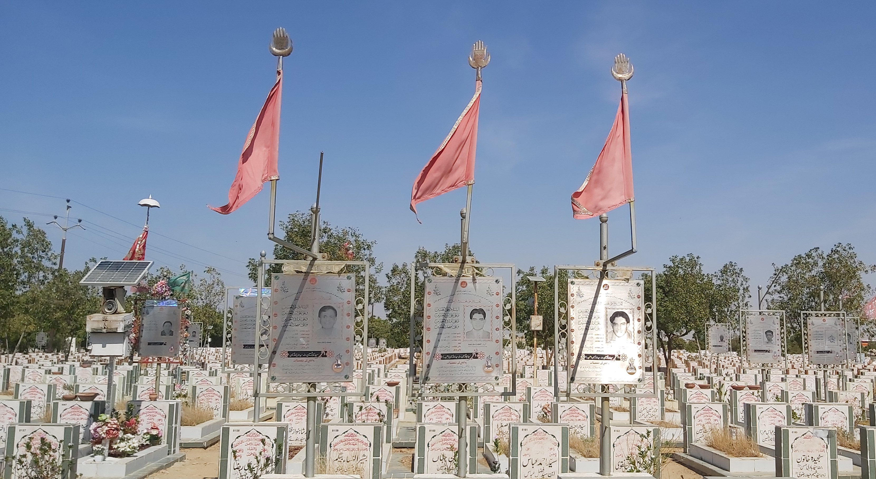 Red flags on the graves indicate the person was killed for being a Shia [Sana Batool/Al Jazeera]
