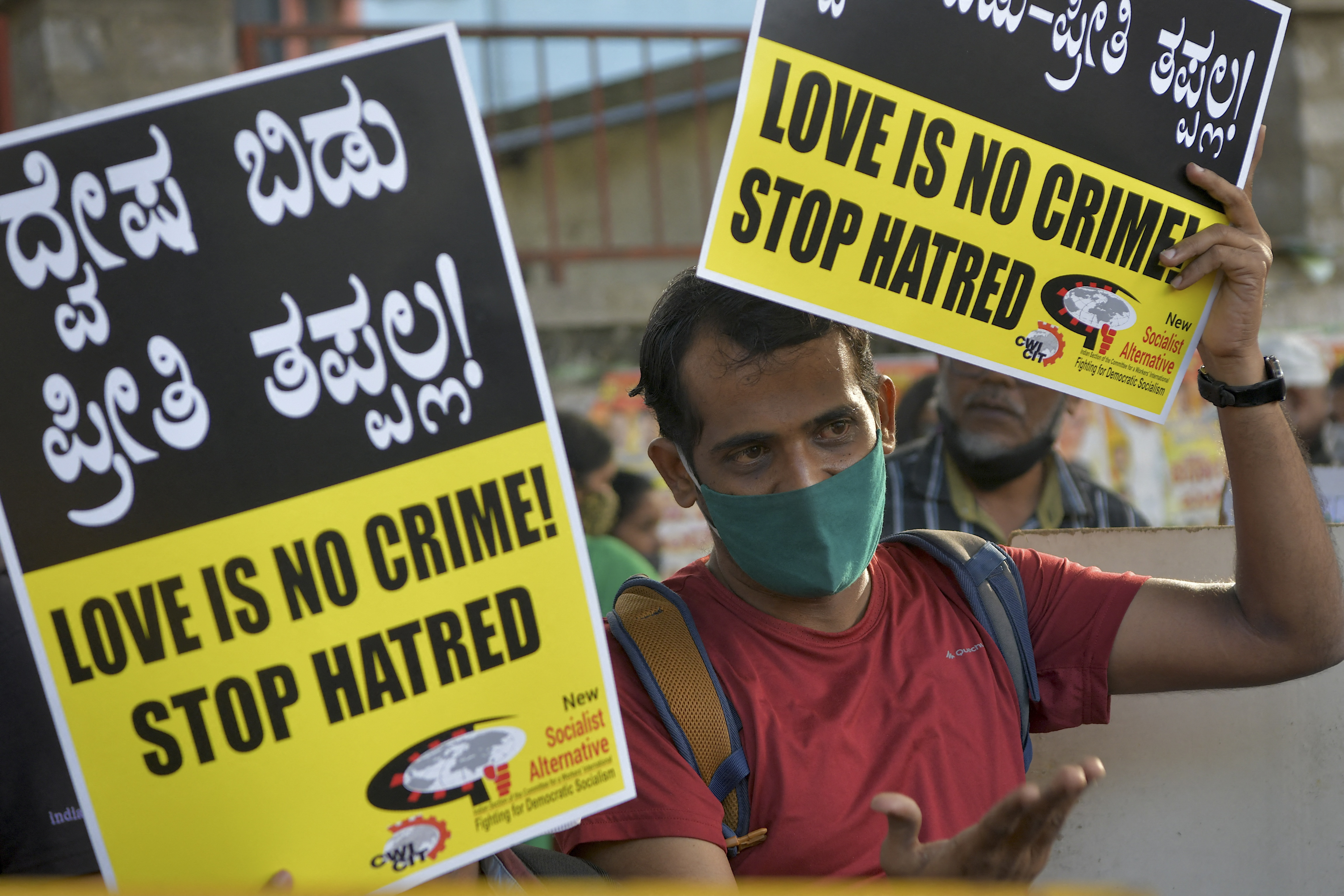 An activist holds placards during a demonstration condemning the decision of various BJP-led state governments to pass 'love jihad' laws, in Bangalore [File: Manjunath KiranAFP]