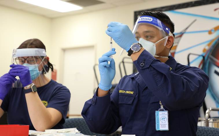 Lieutenant Sara Mantick, pharmacist, and Lieutenant Christopher Mendoza-Troung, acting chief pharmacist, begin drawing COVID-19 vaccines at the Zuni Comprehensive Health Center in New Mexico on December 16, 2020 [Courtesy of IHS]