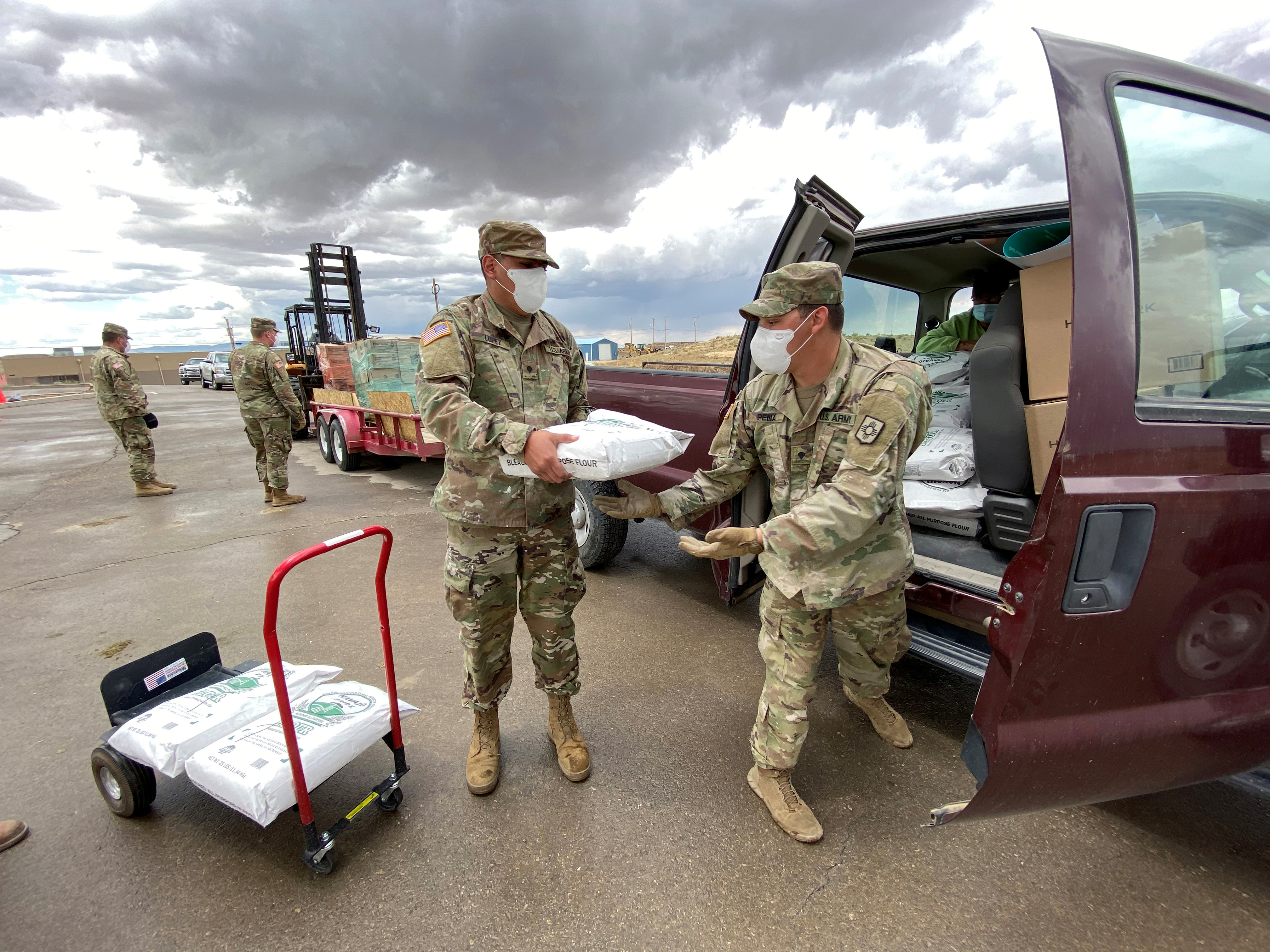 Members of the New Mexico Army National Guard put bags of flour into a truck as they assist with food distribution throughout the Navajo reservation amid an outbreak of COVID-19 in Standing Rock, New Mexico, in May 2020