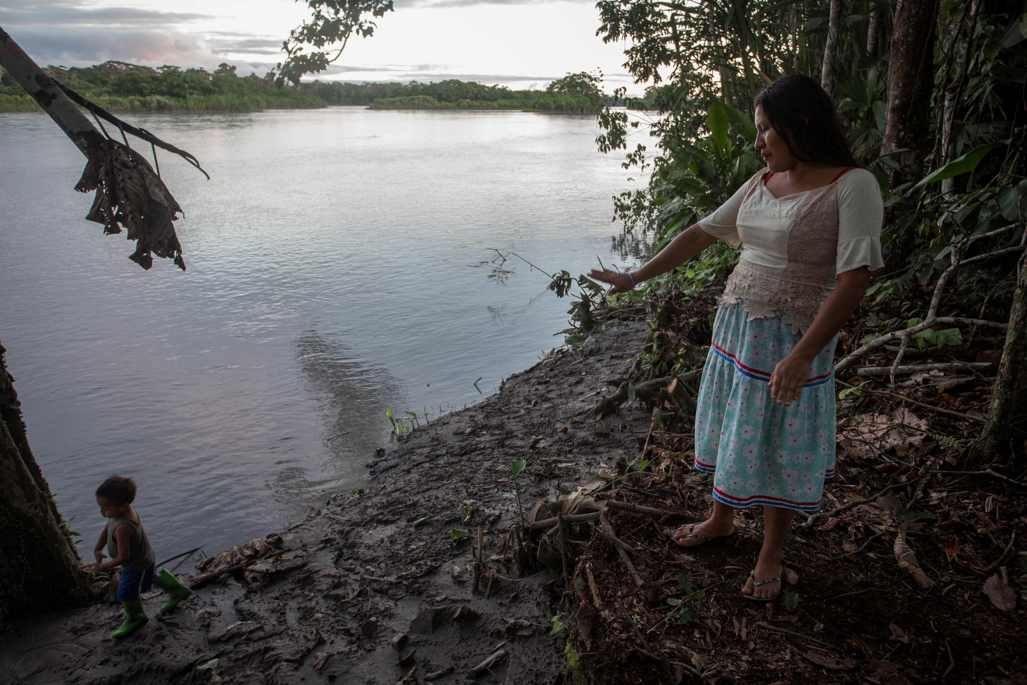 Fanny Licuy gestures to the river banks after oil spill hit her community in Sani Isla, Ecuador on May 9, 2020 [File: Ivan Castaneira/Amazon Watch/Handout via Reuters]