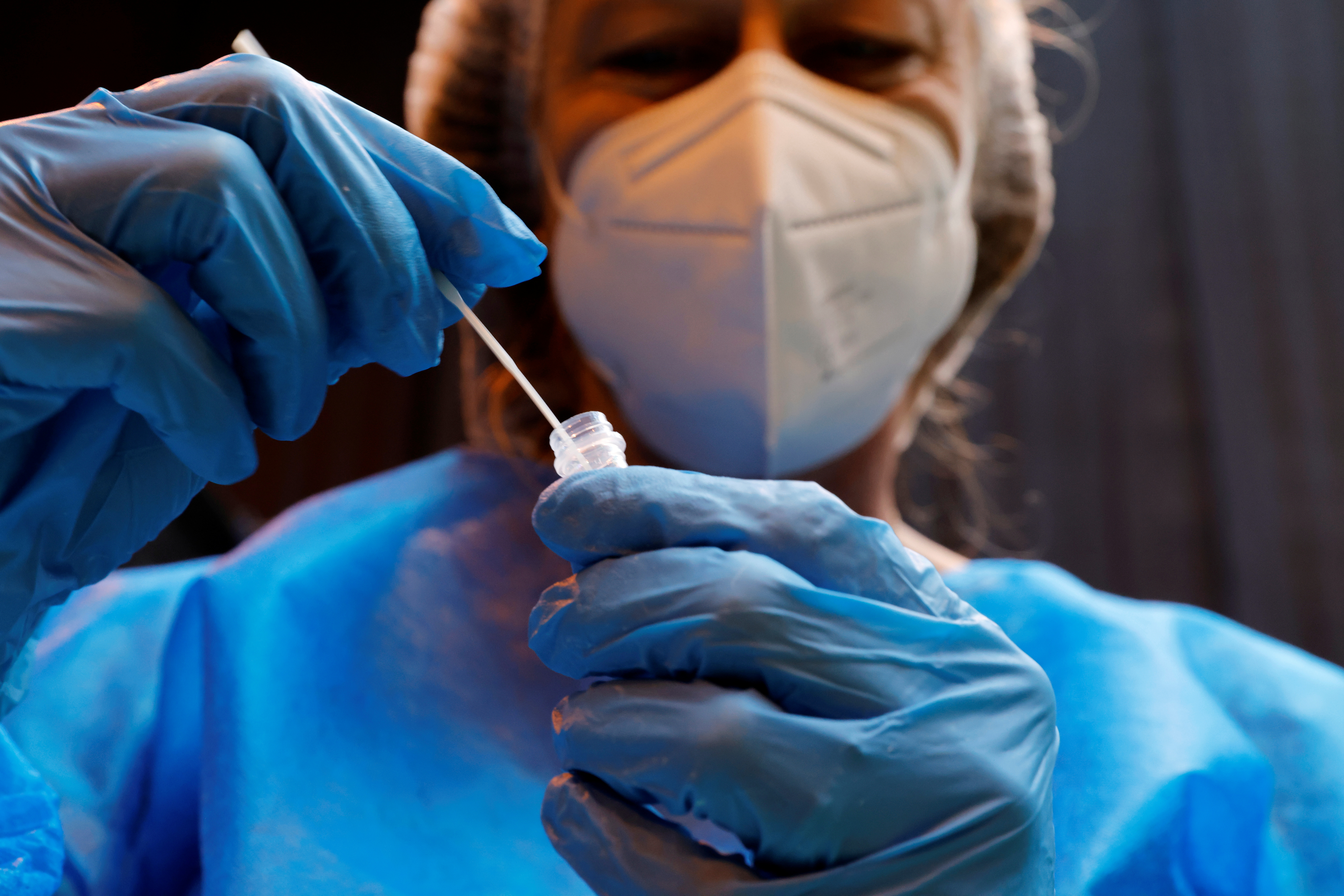 A medical worker holds a test tube after administering a nasal swab to a patient at a coronavirus testing centre in Gravelines, France on February 16, 2021 [Pascal Rossignol/Reuters]
