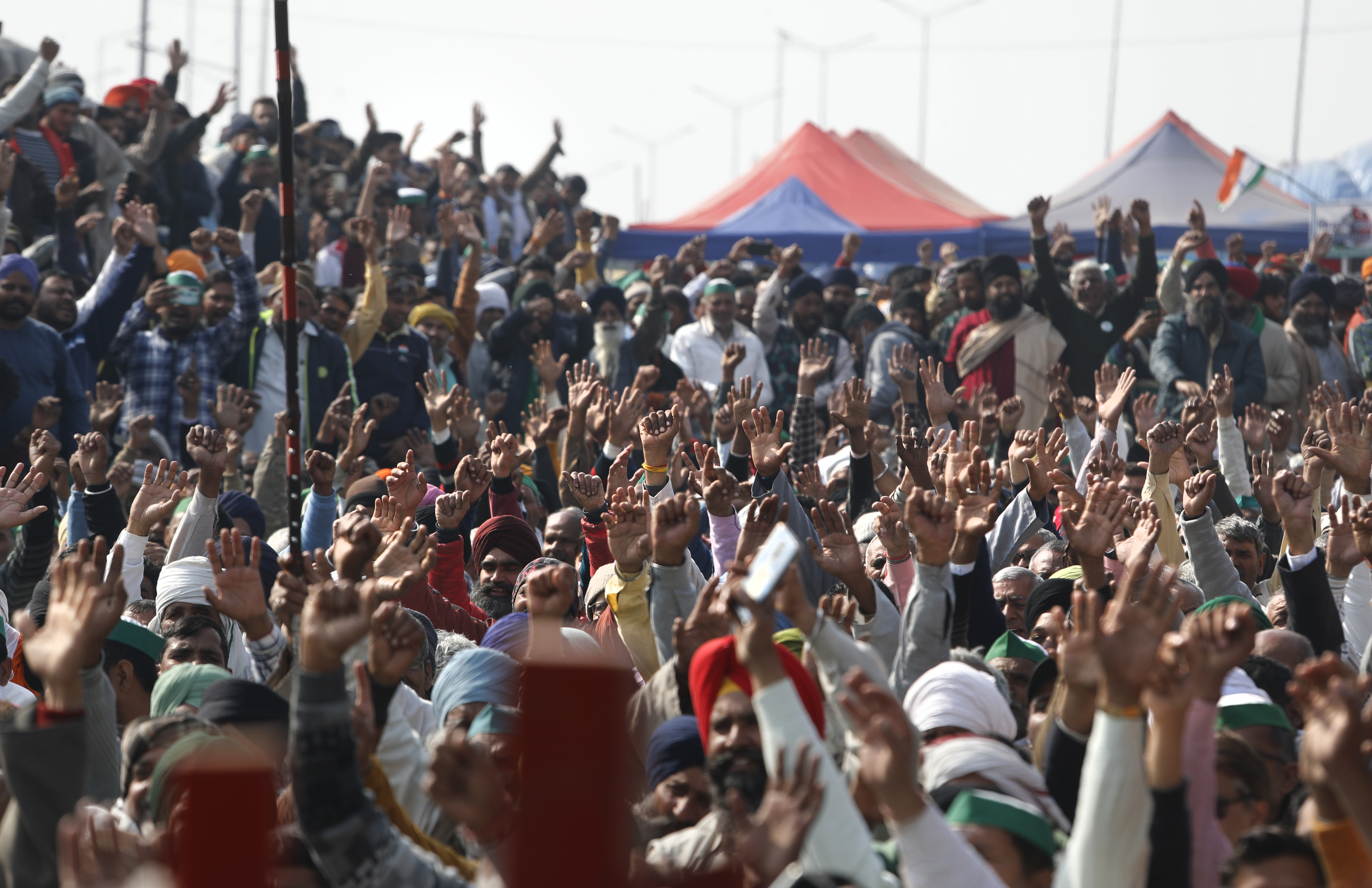 Farmers raise their hand as they shout slogans during a day-long hunger strike to protest against new farm laws, at the Delhi-Uttar Pradesh border, on the outskirts of New Delhi, India, January 30, 2021 [Manish Swarup/AP Photo]