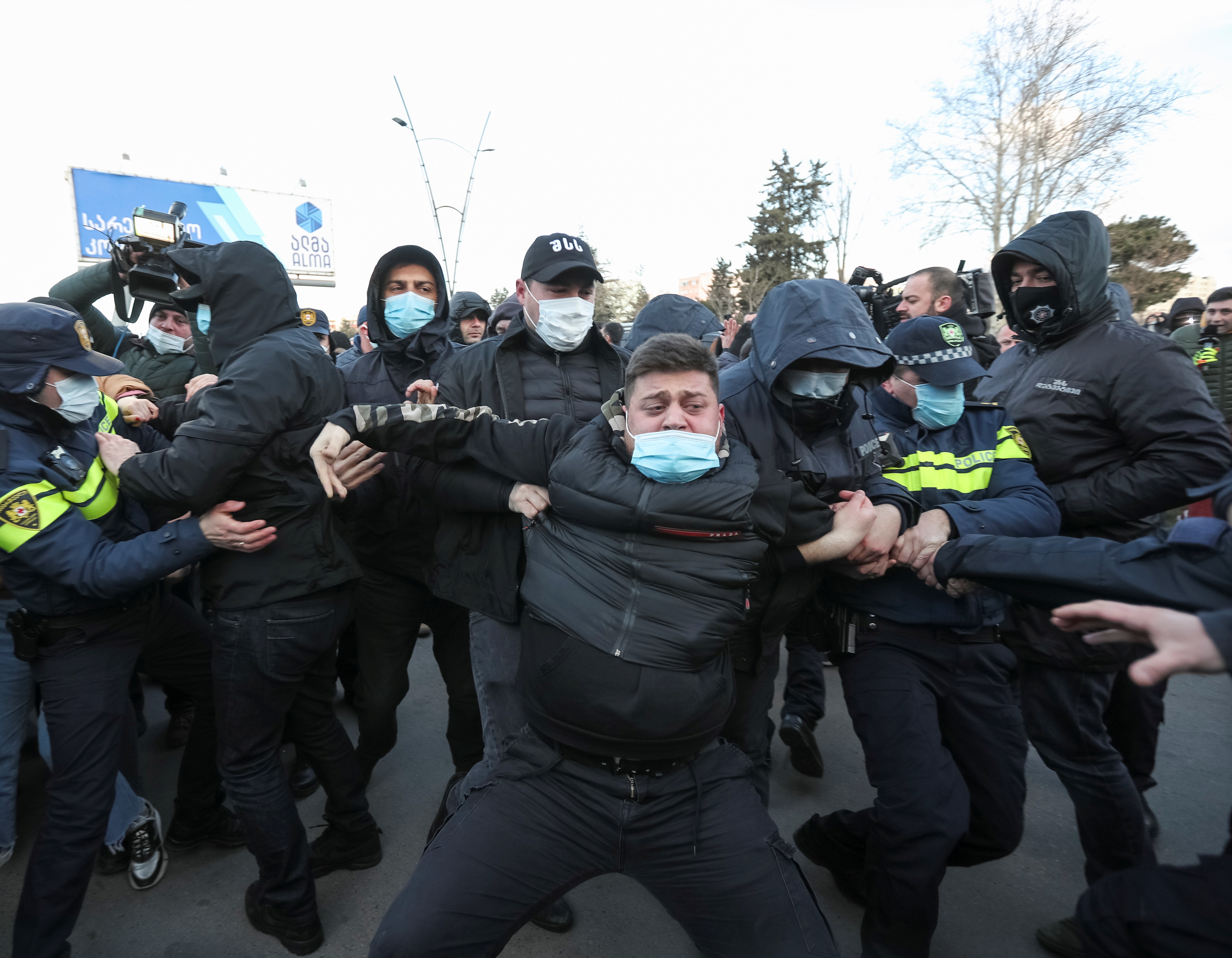 Georgian security officers detain an opposition supporter after storming the United National Movement (UNM) opposition party office in Tbilisi on Tuesday