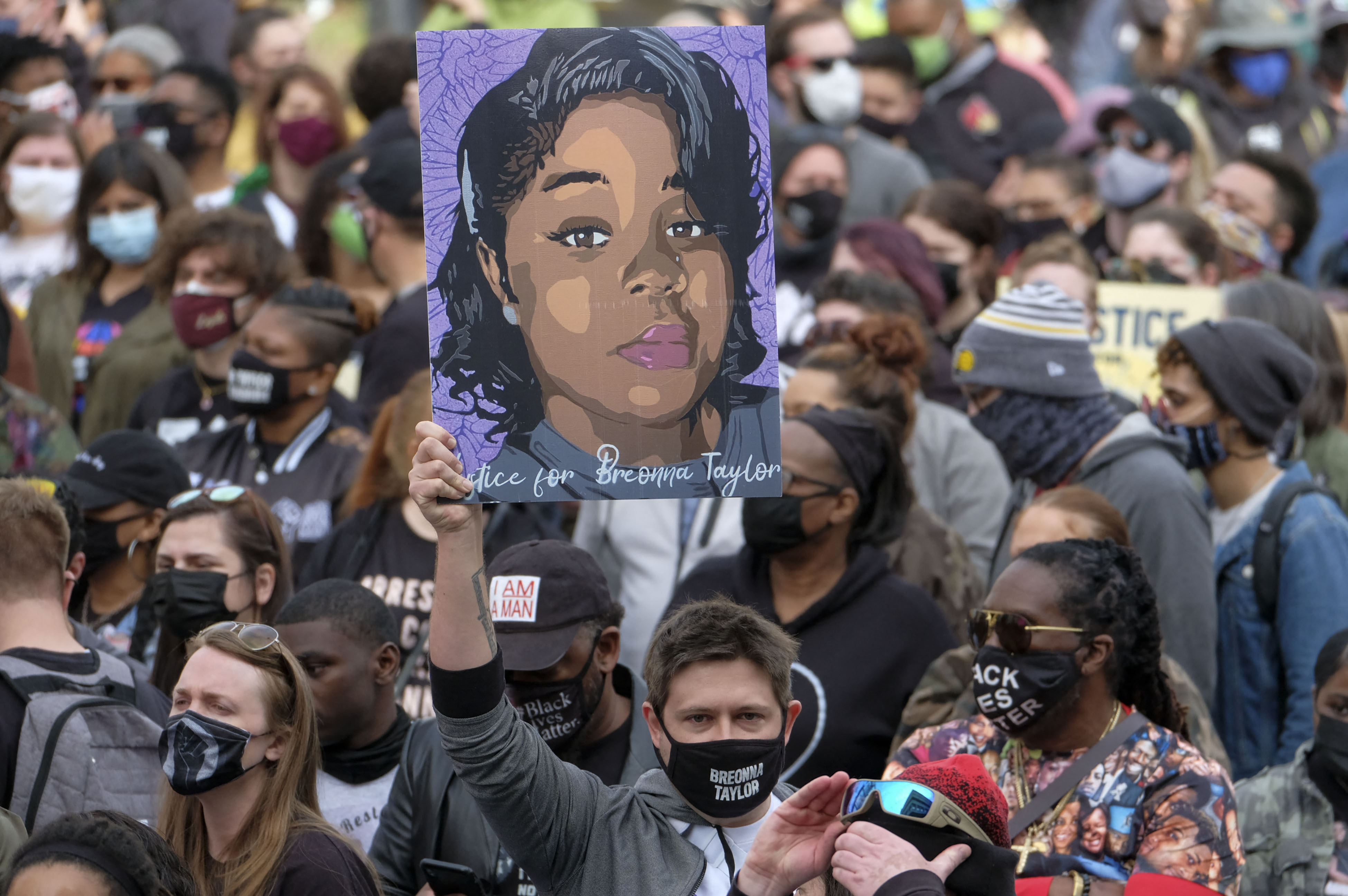 A protestor brandishes a portrait of Breonna Taylor