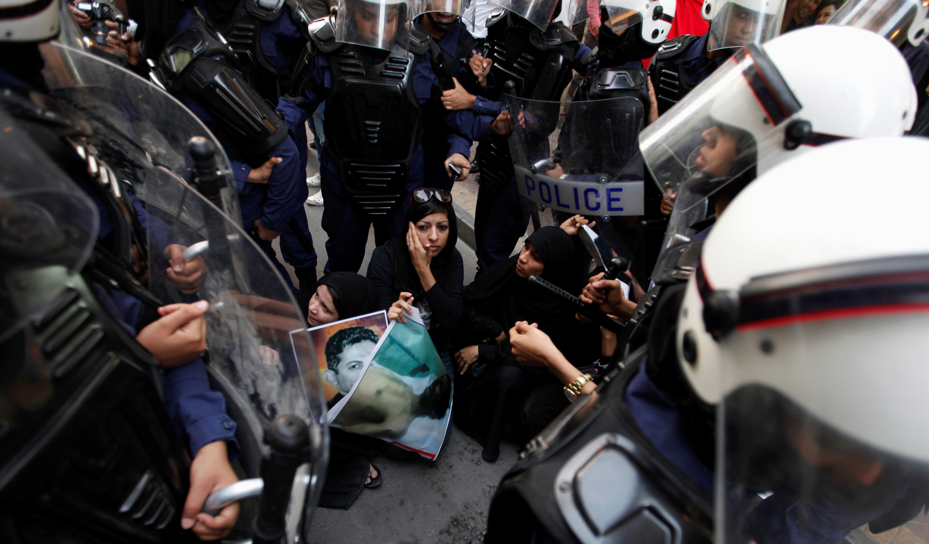 Female riot police officers surround Zaynab, daughter of human rights activist Abdulhadi al-Khawaja, during an anti-government rally demanding his release in Manama, in 2012 [File: Hamad I Mohammed/Reuters]