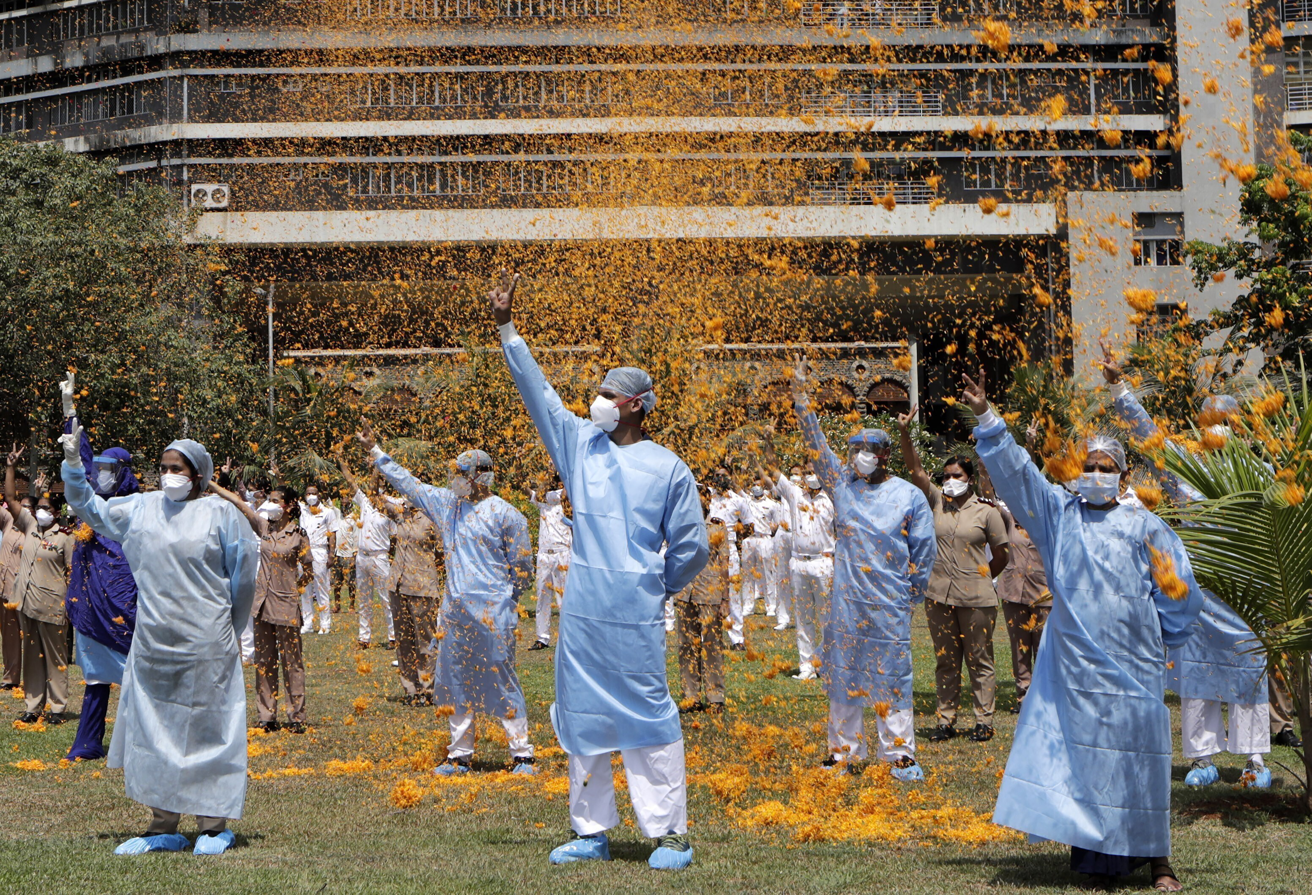 In this May 3, 2020, file photo, an Indian Air Force helicopter showers flower petals on the staff of INS Asvini hospital in Mumbai to thank front-line workers [File: Rajanish Kakade/AP]