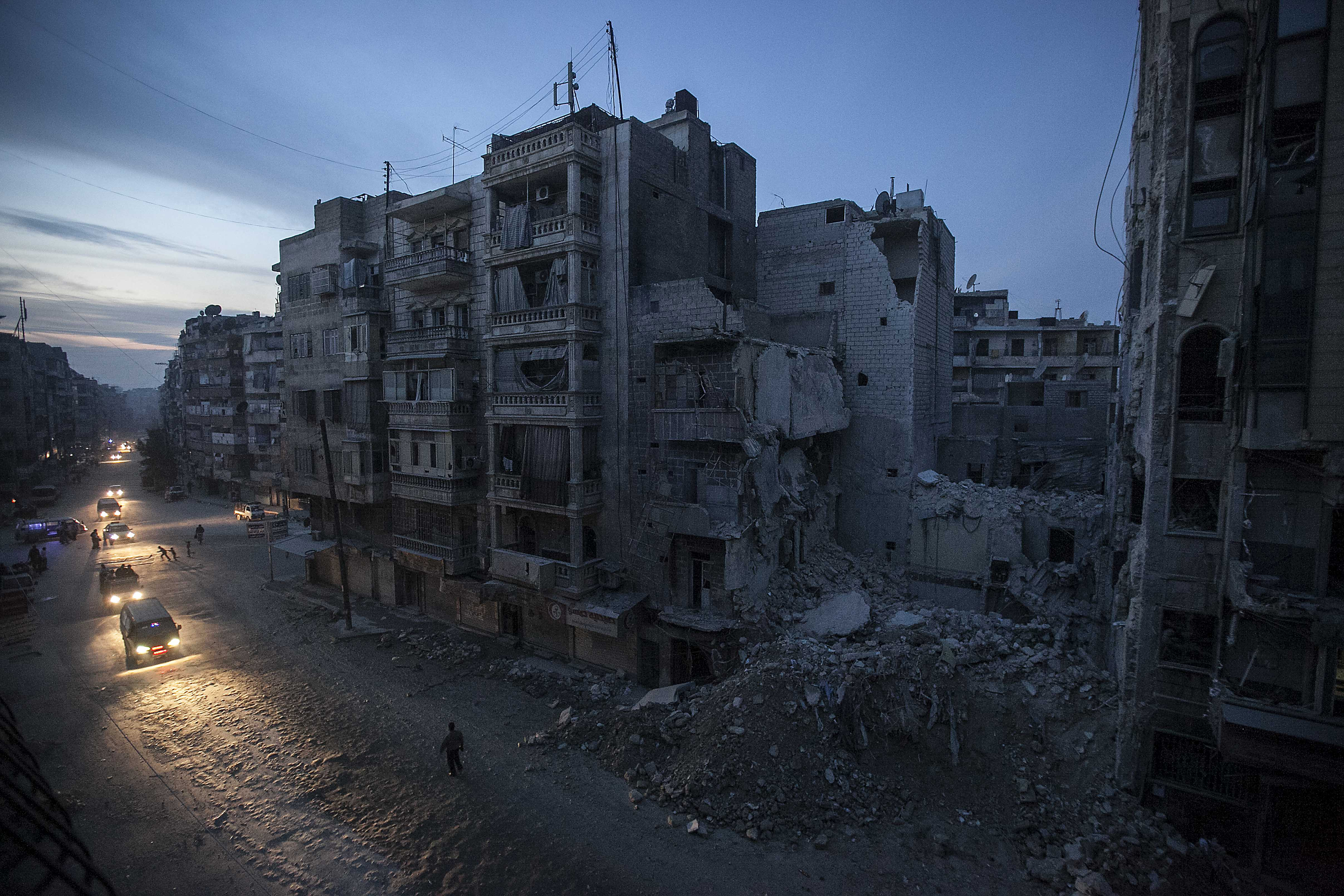 In a photo from November 29, 2012, night falls on a rebel-controlled area of Aleppo as destroyed buildings, including Dar Al Shifa hospital, are seen on Sa'ar street after airstrikes had targeted it a week before [Narciso Contreras]