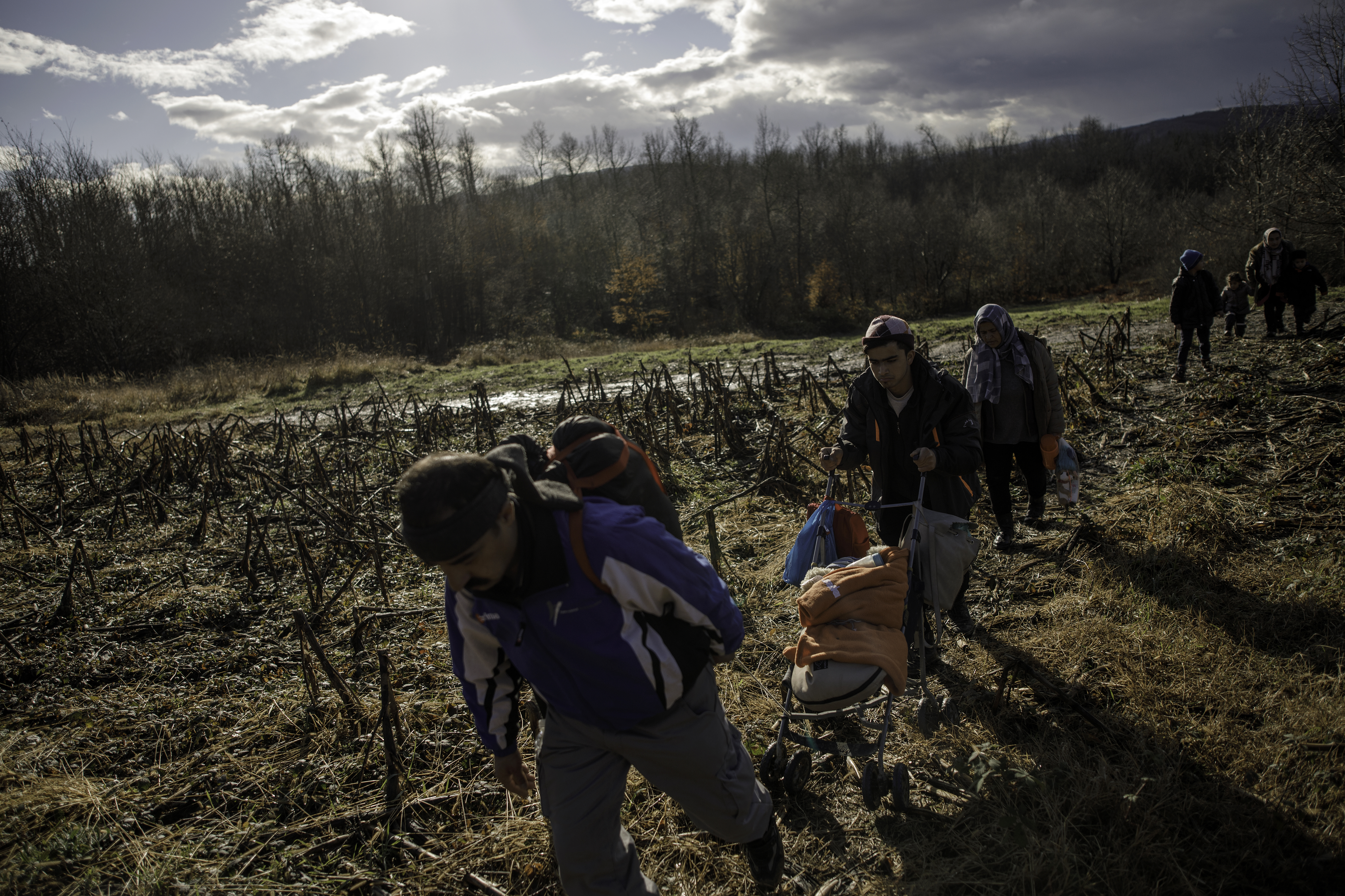 A baby is pushed in a stroller as members of a migrant family from Afghanistan approach Croatia's border from Bosnian side in an attempt to cross into EU by foot, on January 6, 2021 in Bosnia and Herzegovina [Damir Sagolj/Getty Images]