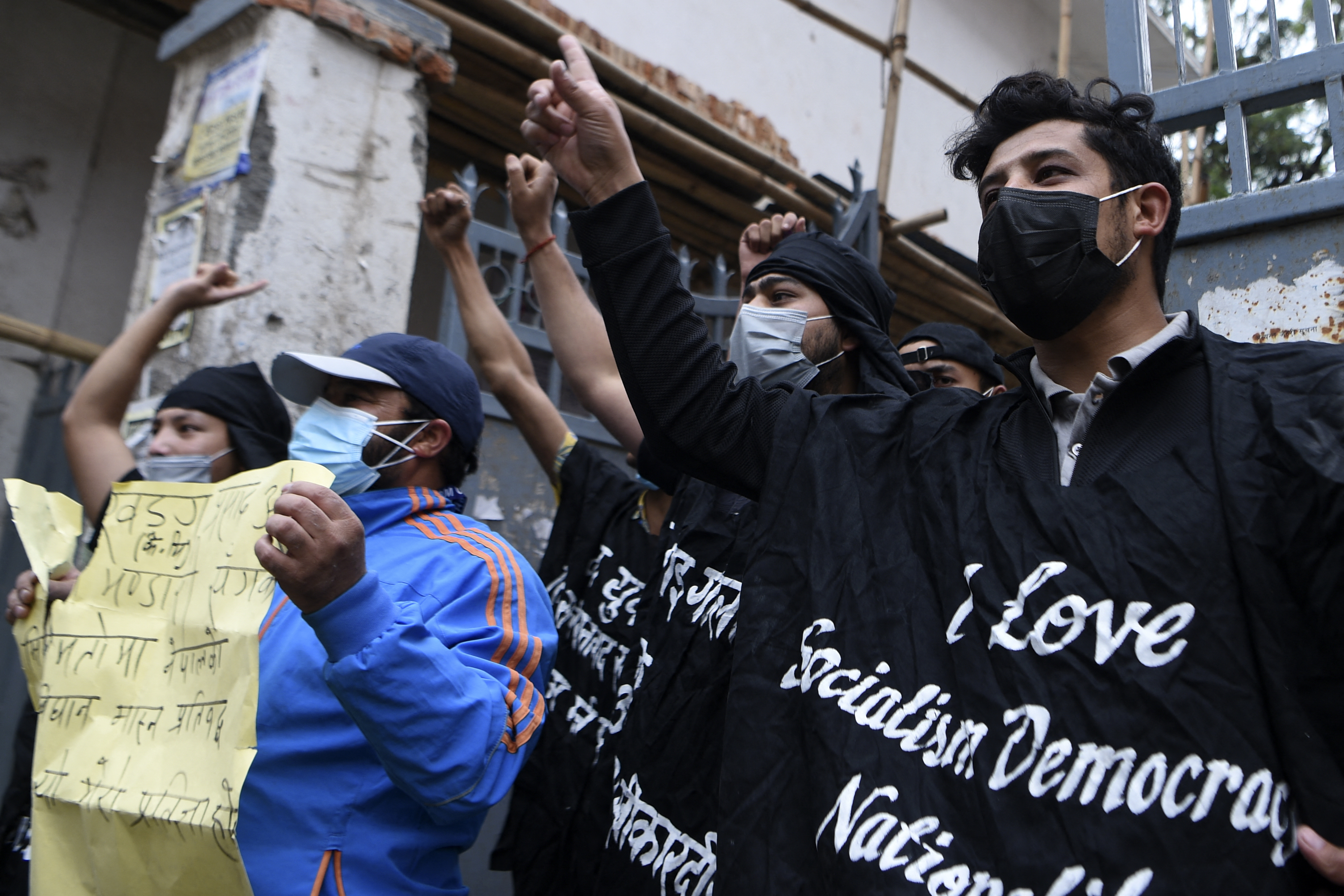 Protesters from the Nepalese Students Union shout slogans after burning an effigy of Nepal's President Bidhya Devi Bhandari and Prime Minister KP Sharma Oli during a demonstration, in Kathmandu on May 25, 2021 [Prakash Mathema/ AFP]