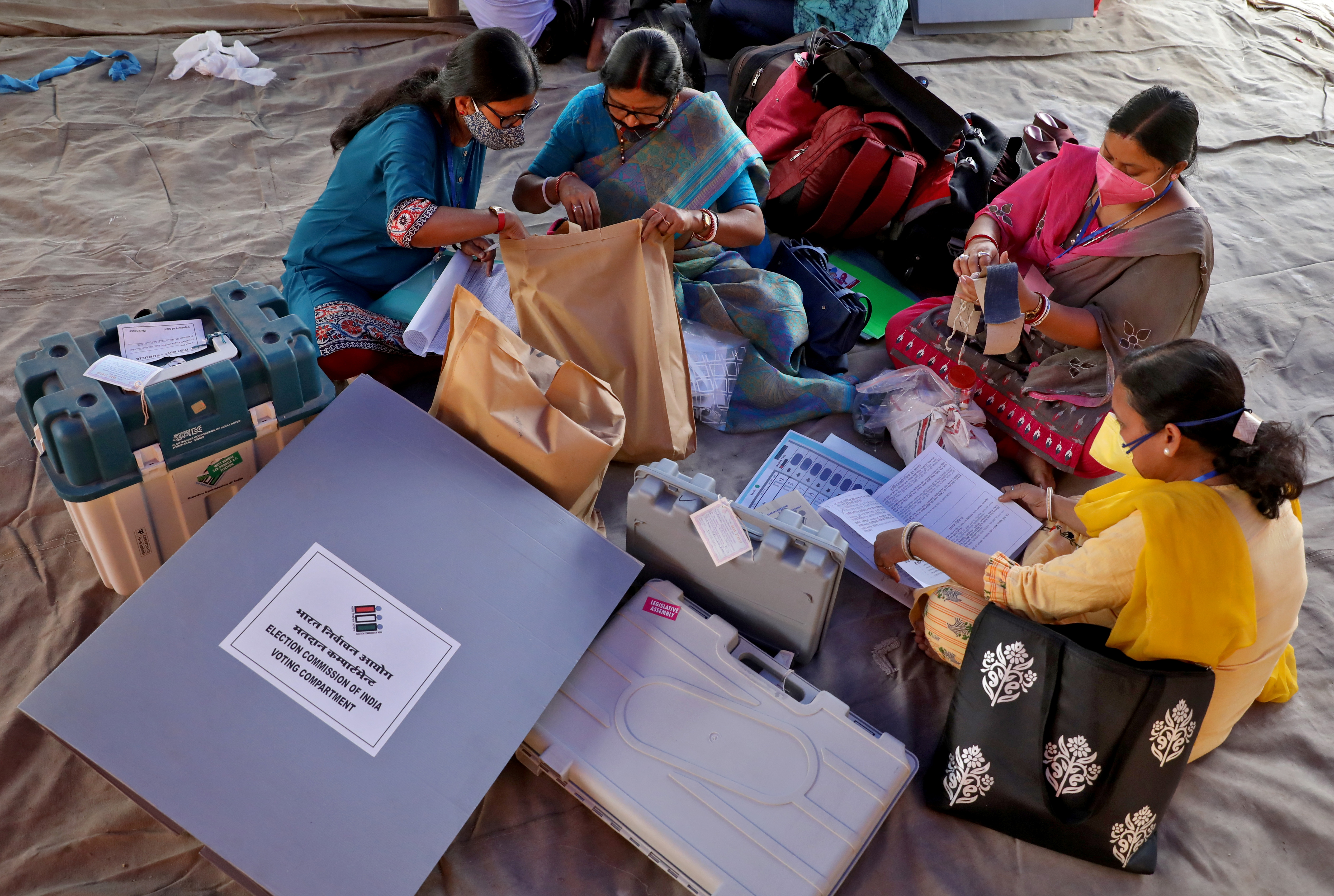 Polling officials check election materials after collecting them from a distribution centre ahead of the first phase of West Bengal state assembly election, in Purulia district, India