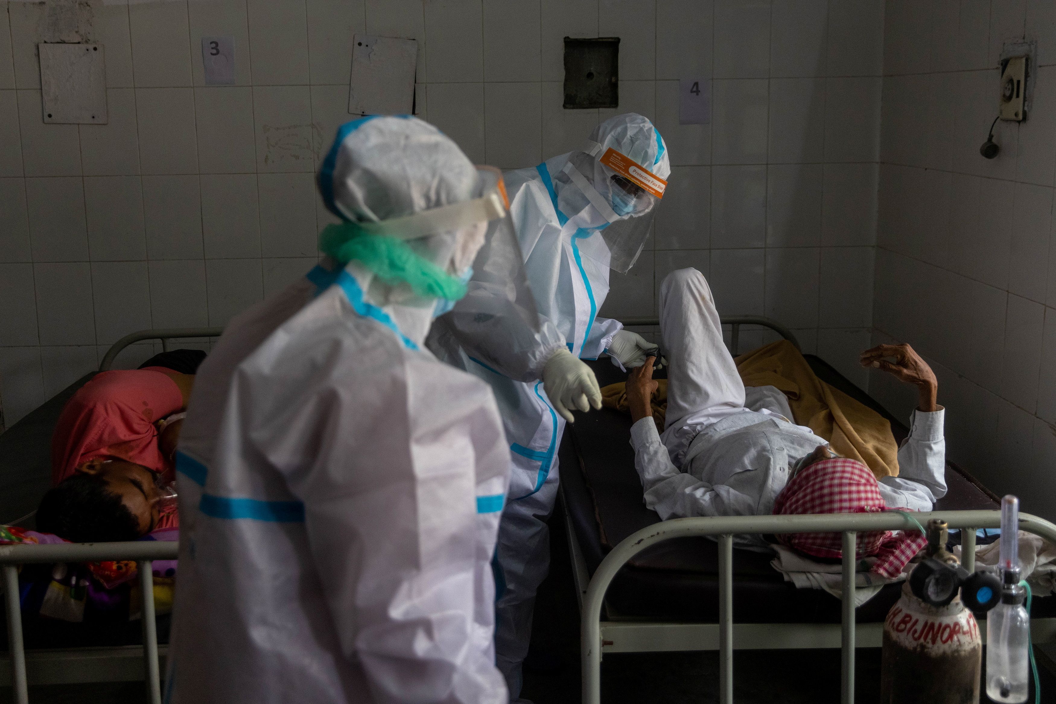Medics tend to a man with breathing problems inside a COVID-19 ward of a government-run hospital, amidst the coronavirus disease (COVID-19) pandemic, in Bijnor district, Uttar Pradesh, India, May 11, 2021. [Danish Siddiqui/Reuters]
