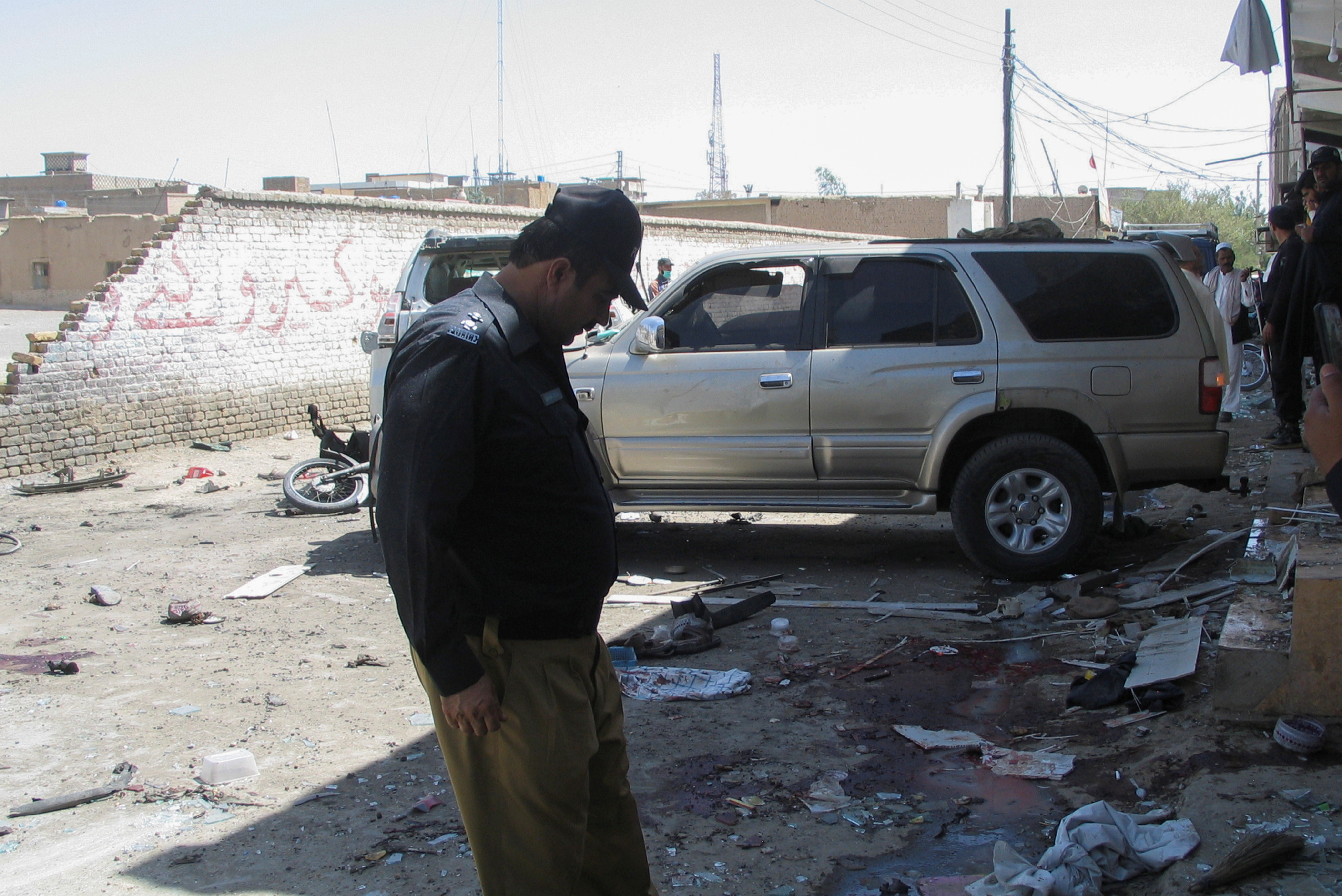 A police officer surveys the site after a bomb blast in Chaman, a Pakistani town on the border with Afghanistan [Saeed Ali Achakzai/Reuters]