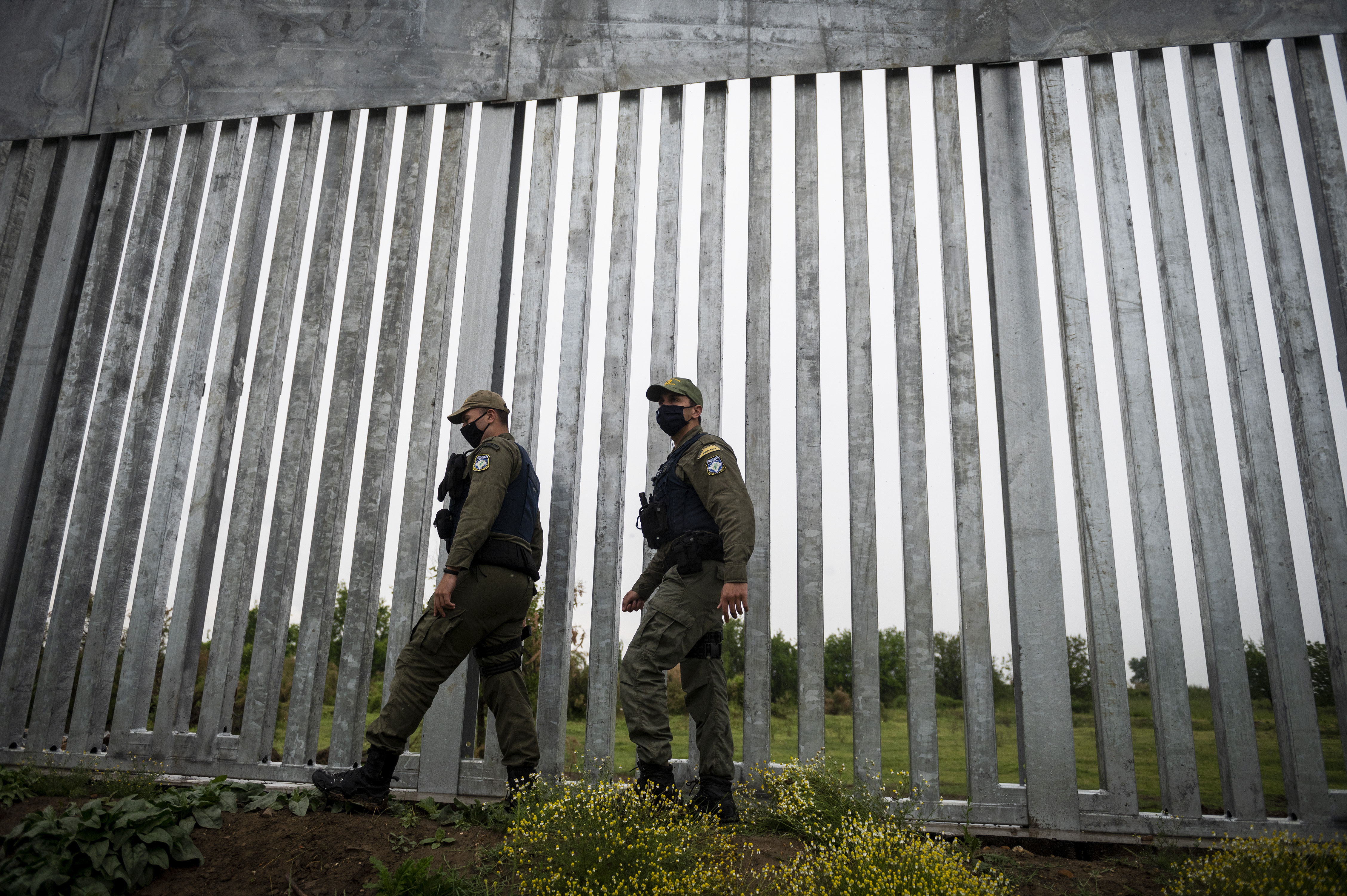 Police officers patrol alongside a steel wall at Evros River, near the village of Poros, at the Greek-Turkish border, Greece