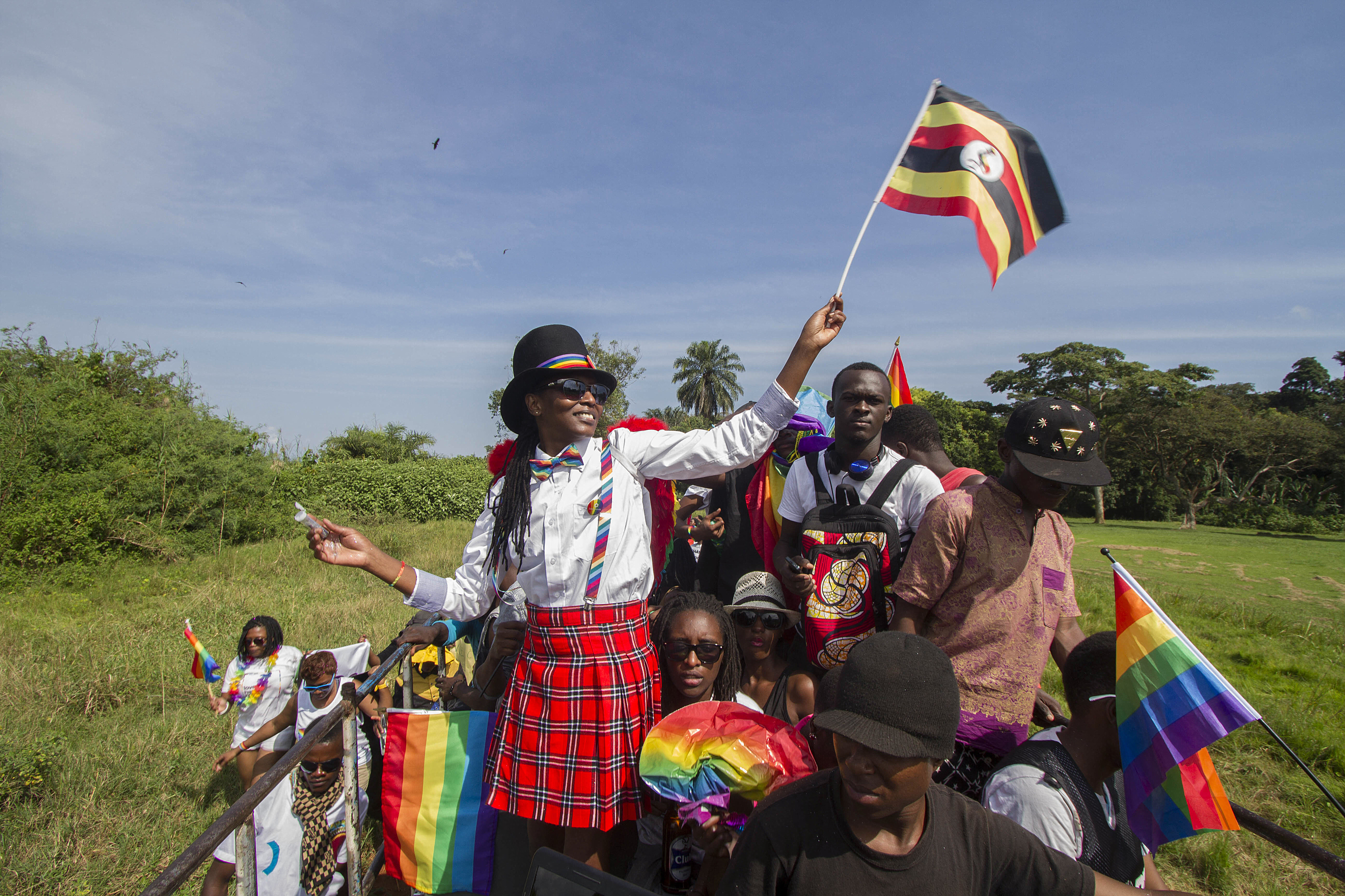 People waving Ugandan and rainbow flags take part in the Gay Pride parade in Entebbe on August 8, 2015 [File: AFP/Isaac Kasamani]