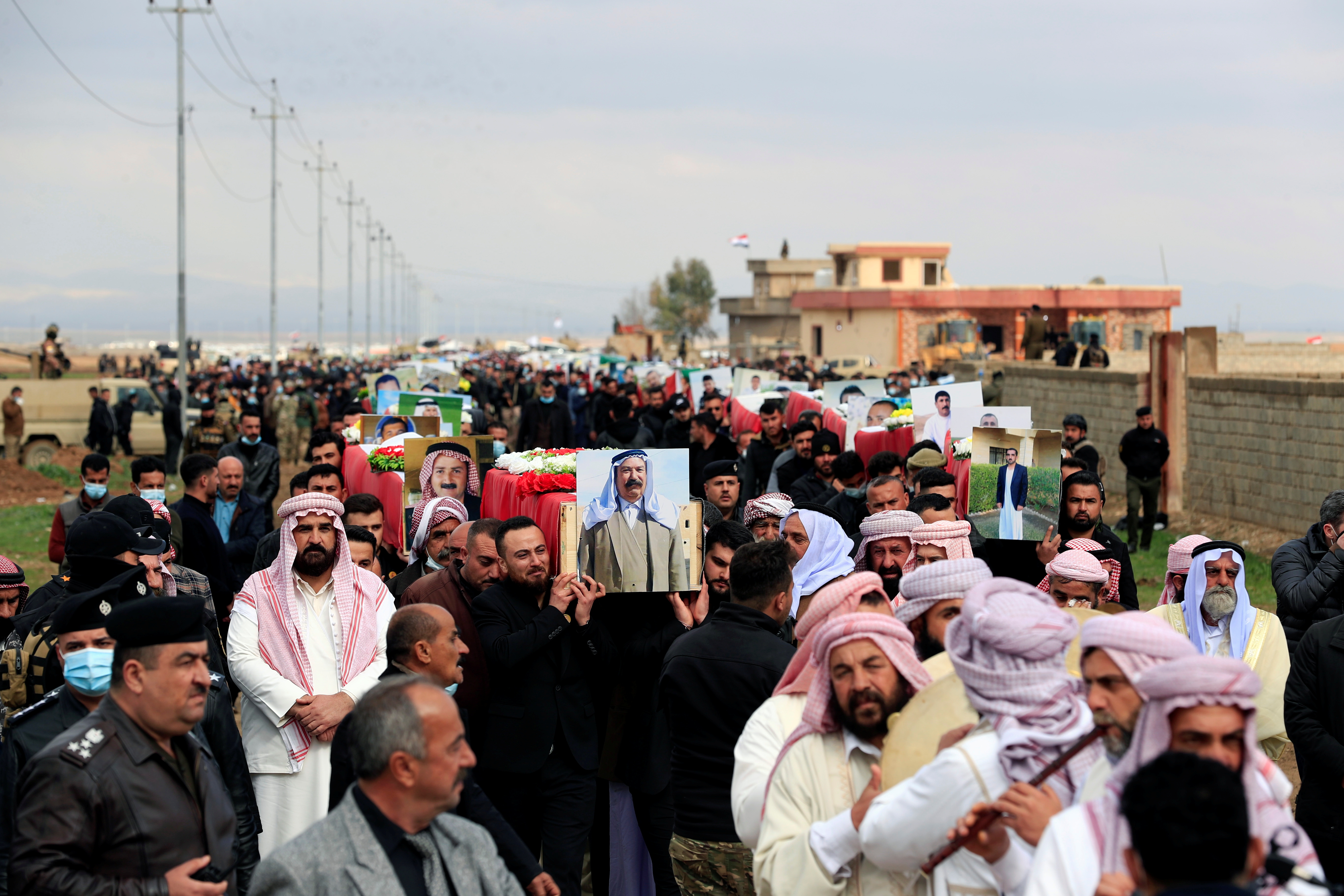 Mourners carry coffins with the remains of people from the Yazidi minority, who were killed by ISIL, after being exhumed from a mass grave, to bury them in Kojo, Iraq on February 6, 2021 [File: Reuters/Thaier al-Sudani]