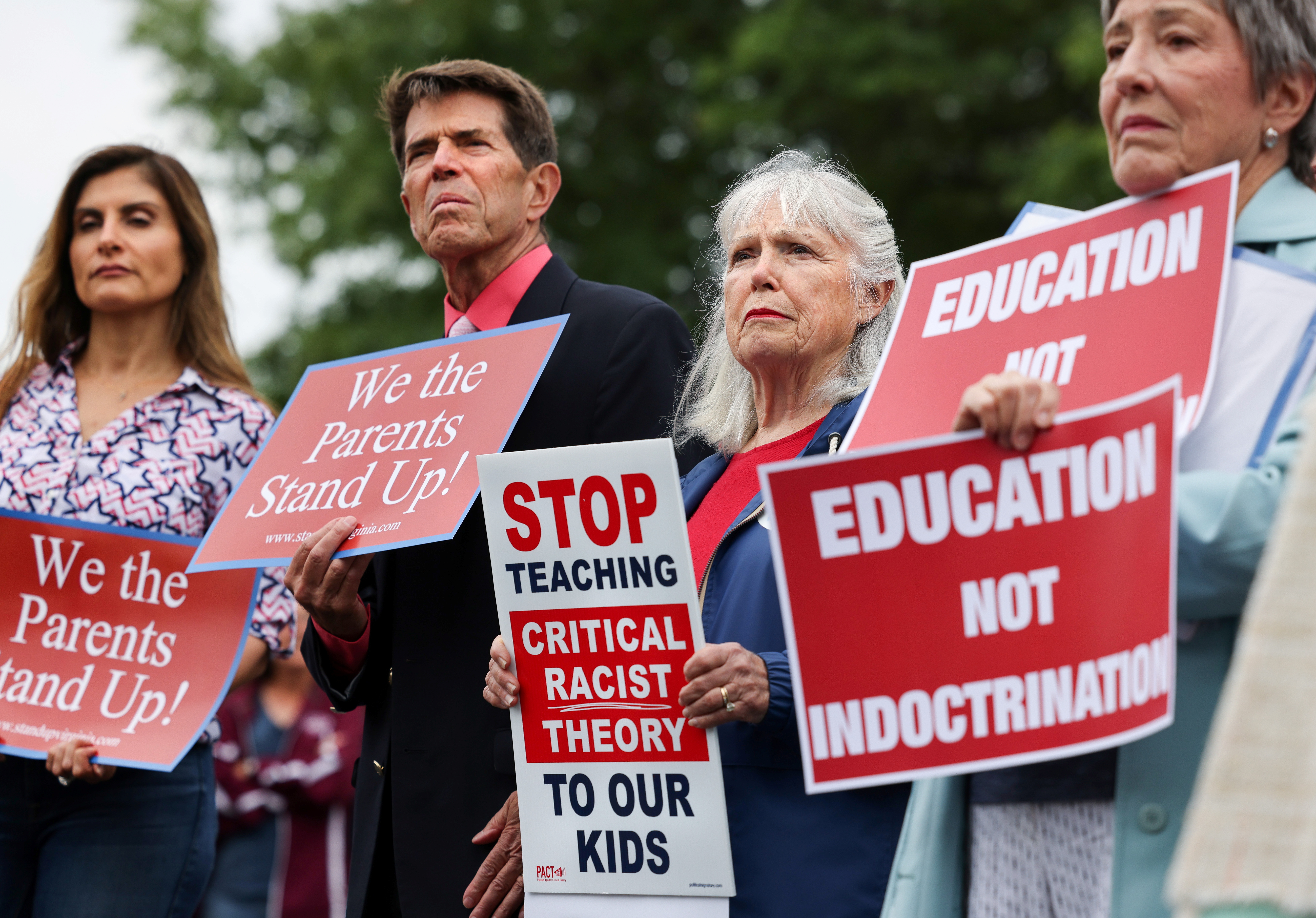 Protesters hold placards that read stop critical race theory at a rally in the US