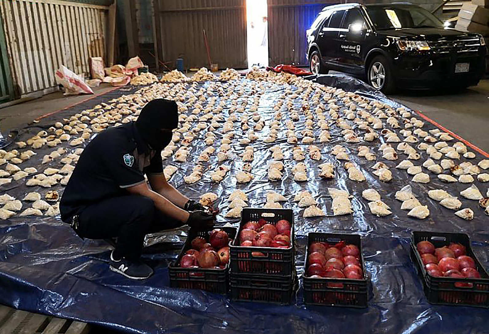 Saudi custom officer opens imported pomegranates, as customs foiled an attempt to smuggle over 5 million Captagon pills in 2021 [File photo: Saudi Press Agency/AP]