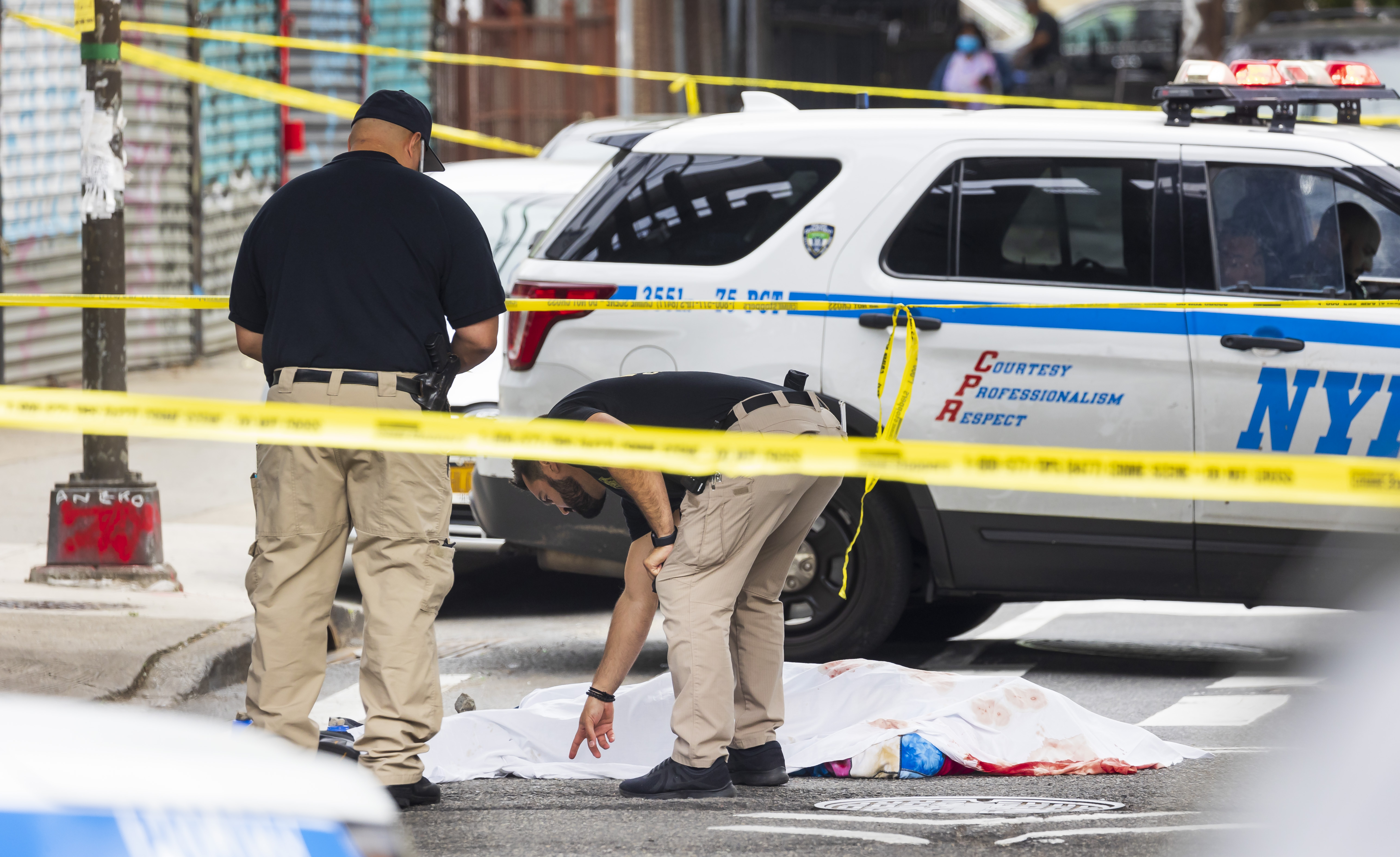 New York City police officers investigate the scene where a man was shot and killed in the Brooklyn borough, June 11, 2021 [Justin Lane/EPA-EFE]