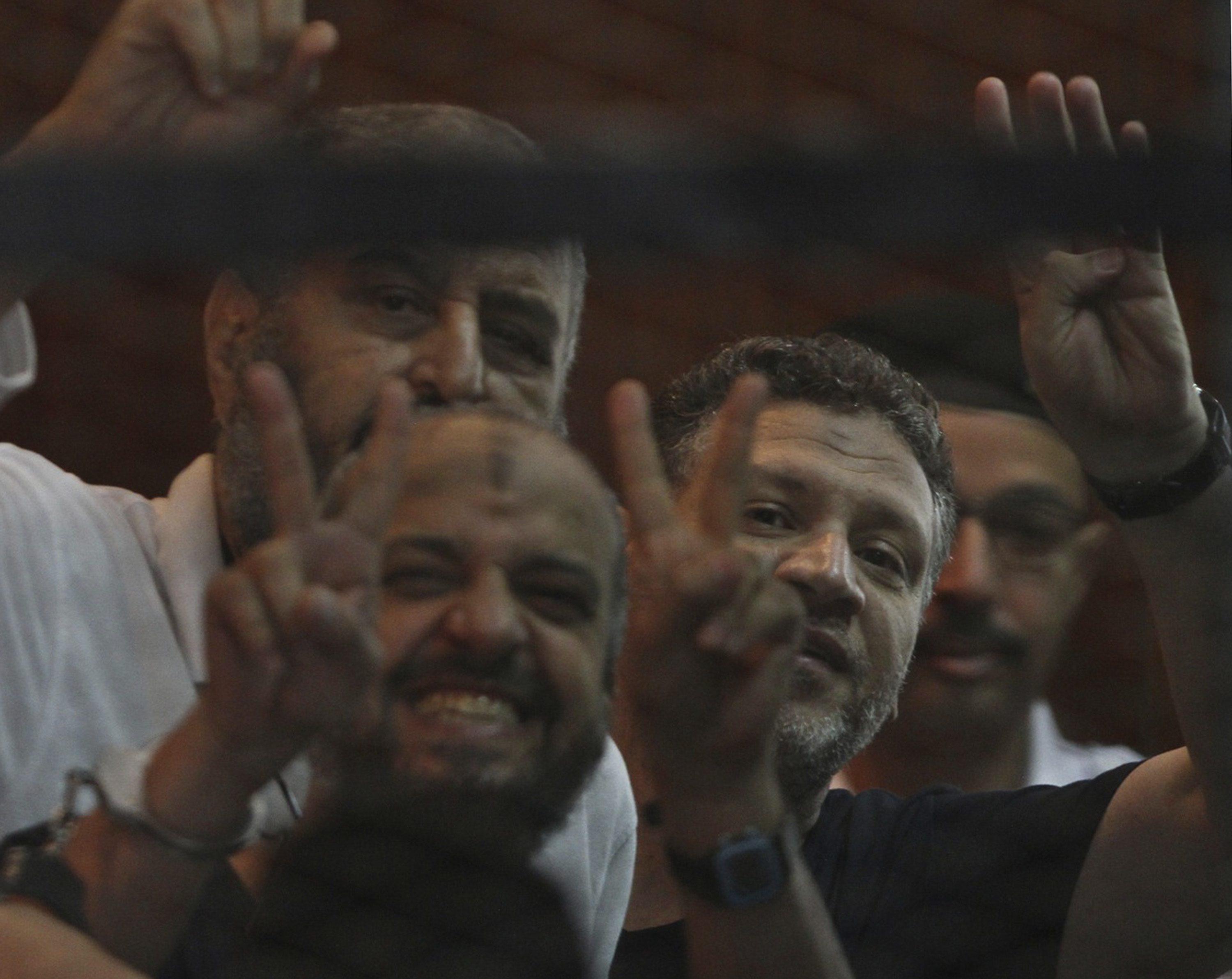 Muslim Brotherhood leading figures, Mohamed el-Beltagy, Khairat el-Shater, and former youth minister Osama Yassin gesture during their trial at a court in Cairo on August 30, 2014 [File: Reuters]