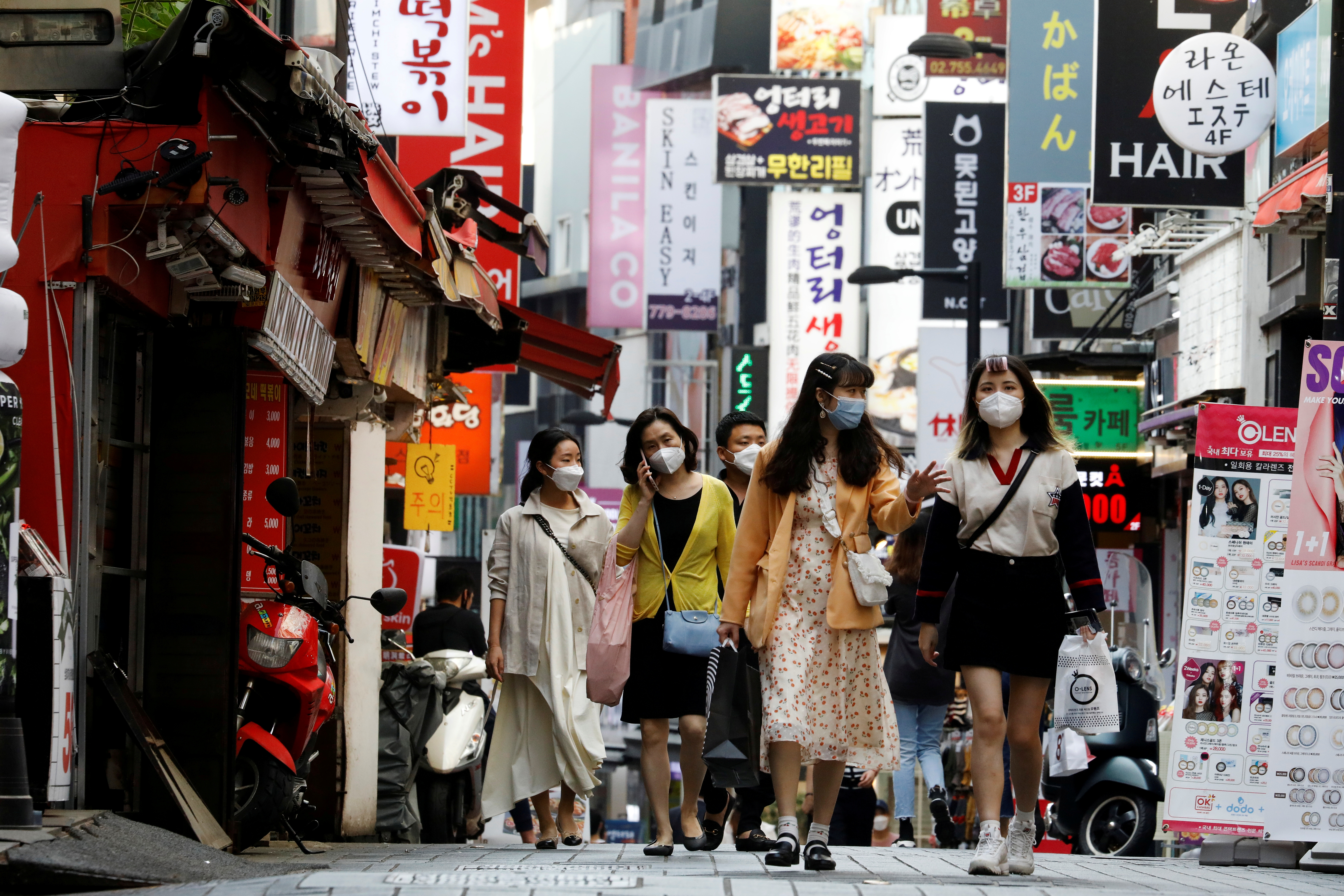Women shoppers walk down a street in Seoul, South Korea