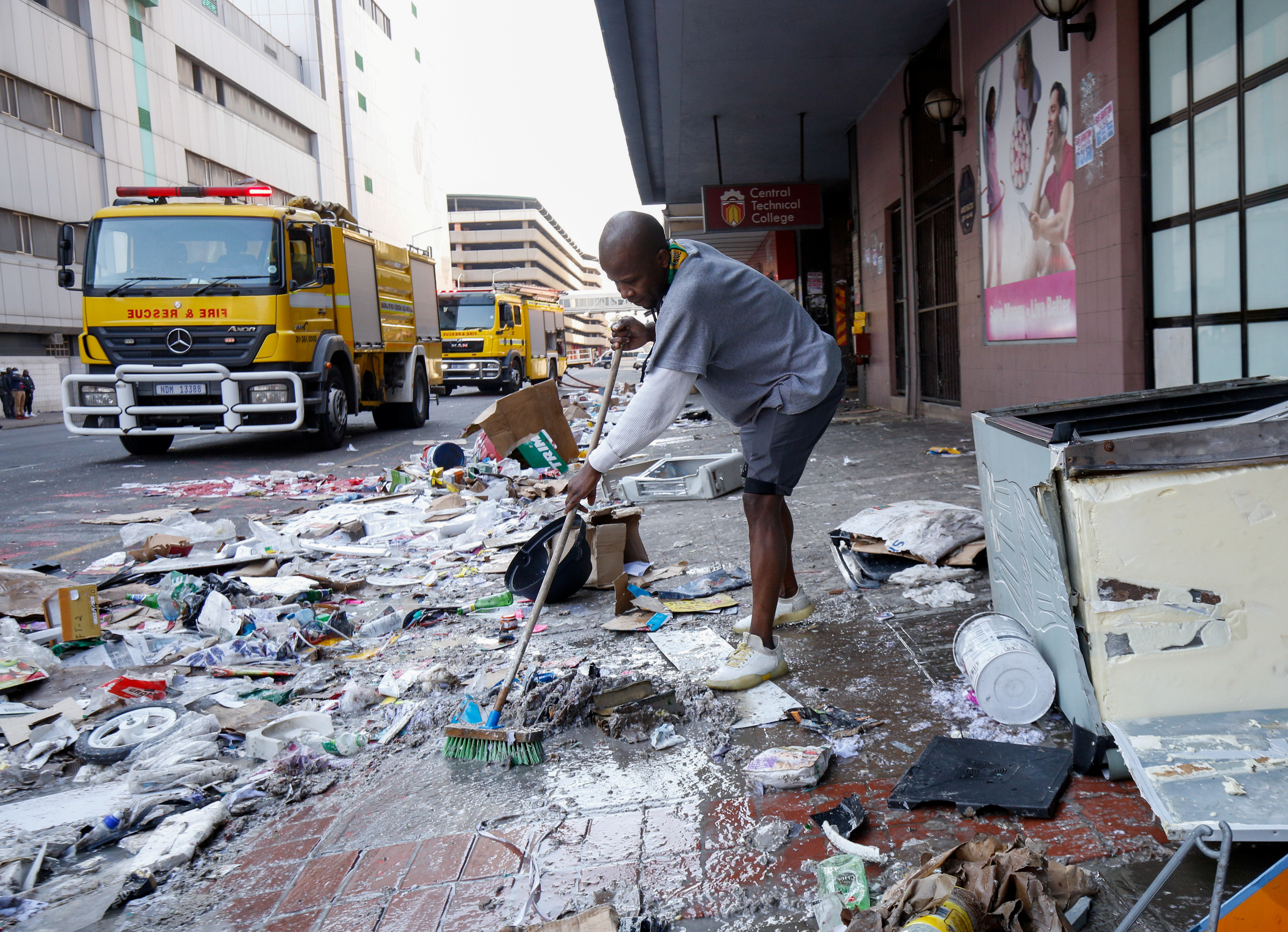 A volunteer cleans the streets in Durban after several days of looting [Rogan Ward/Reuters]