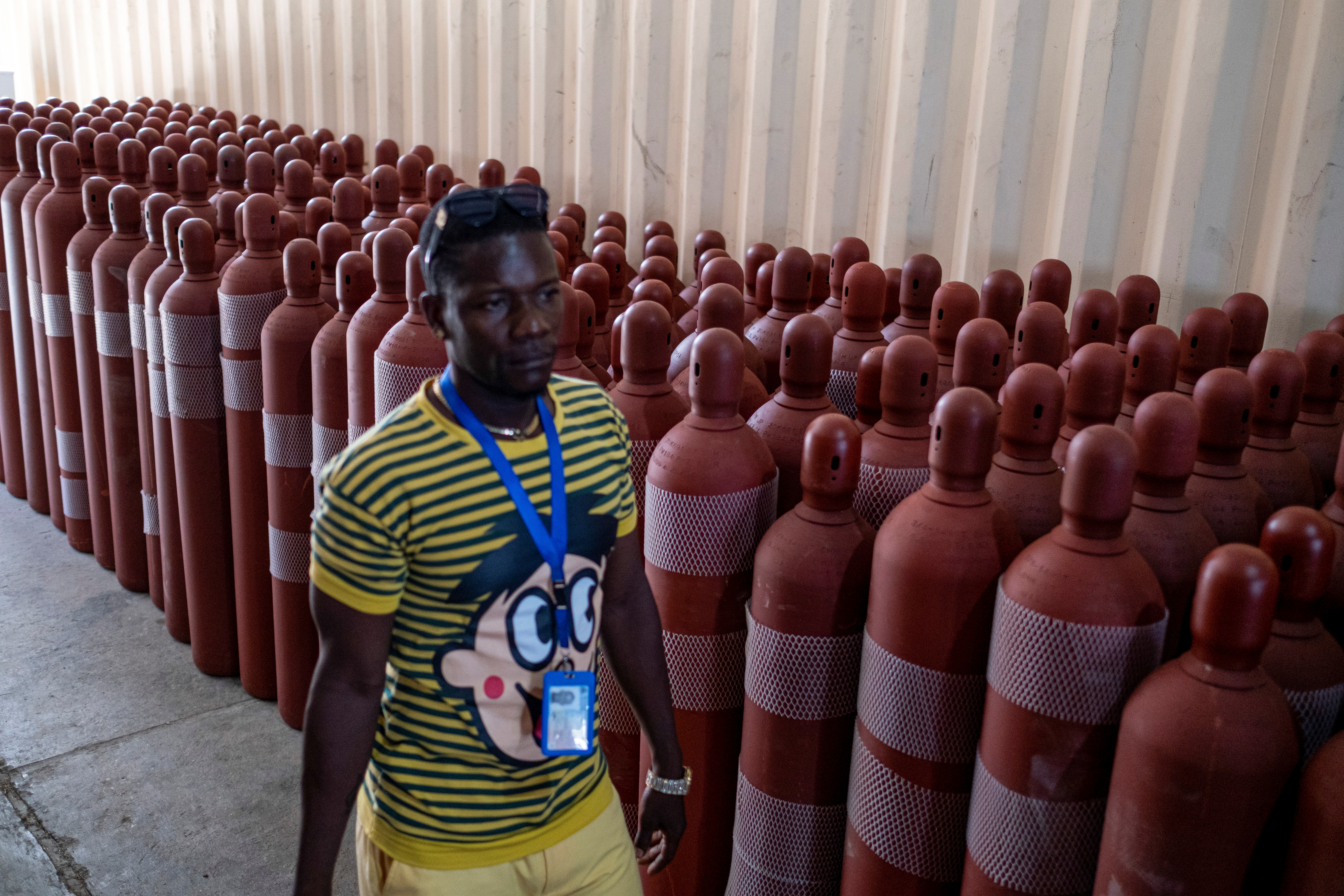 A man walks past oxygen tanks at the St. Luke Foundation for Haiti Hospital, in Port-au-Prince, Haiti