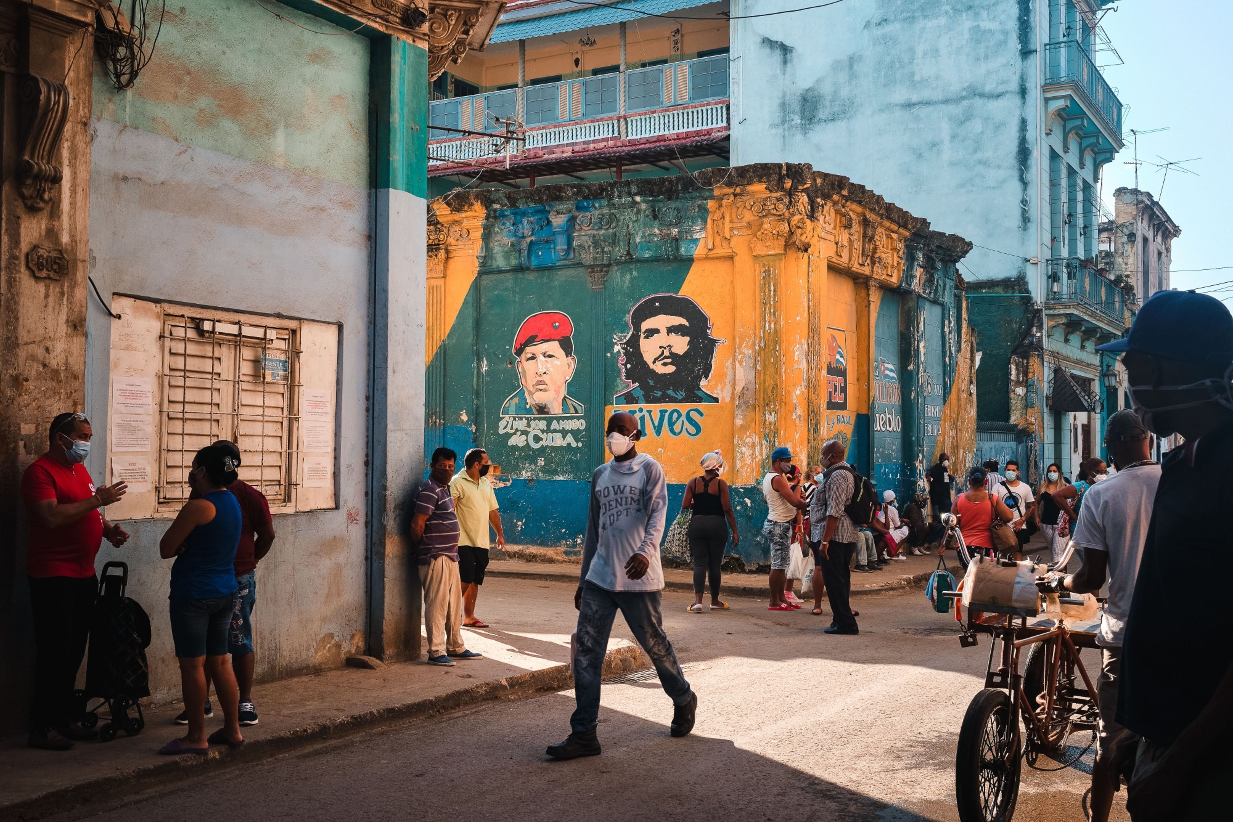 Customers wait in line to enter a grocery store in Havana, Cuba