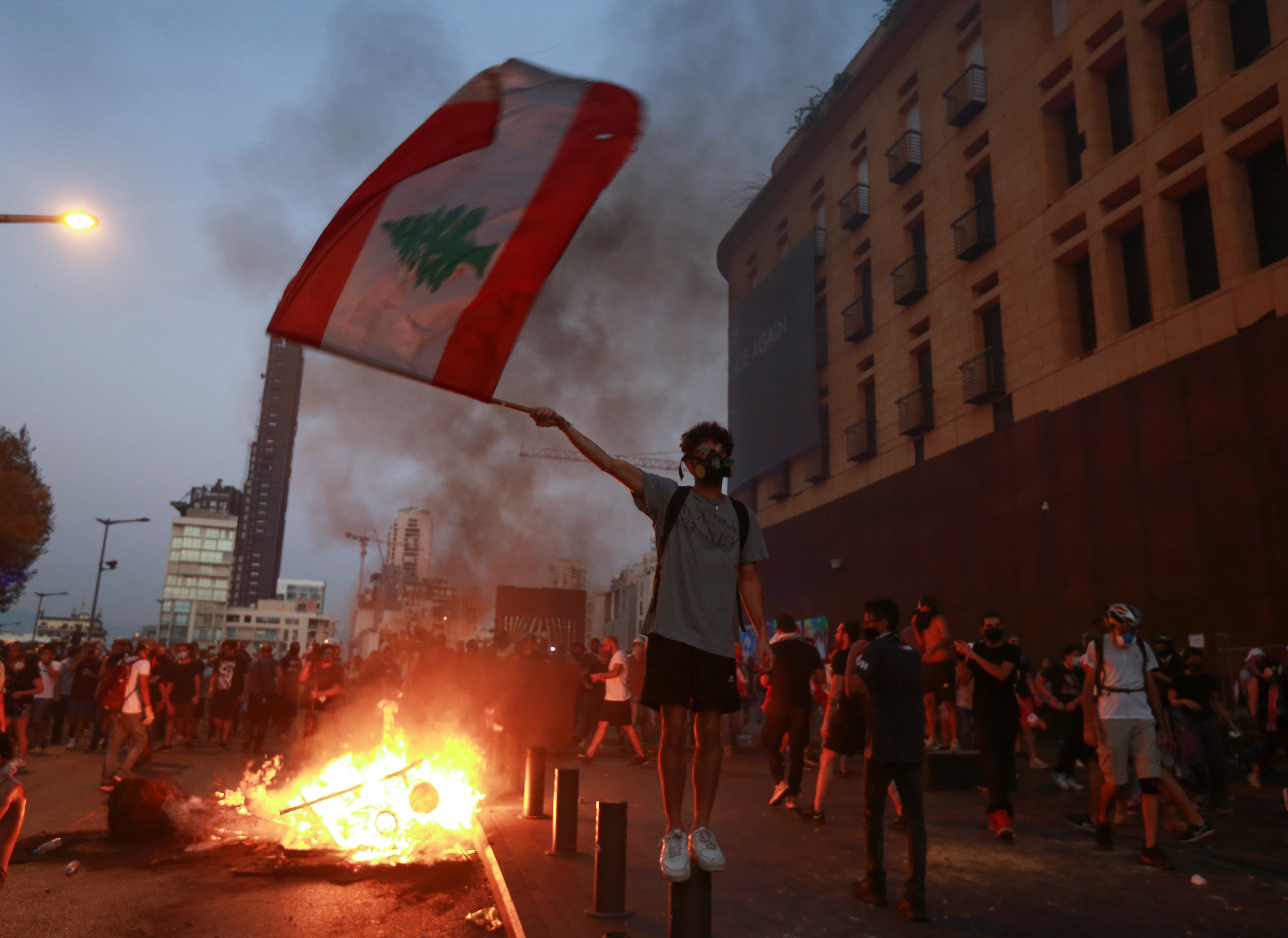 A demonstrator holds the Lebanese flag during a protest near Parliament as Lebanon marks the one-year anniversary of the explosion in Beirut, August 4 [Aziz Taher/Reuters]