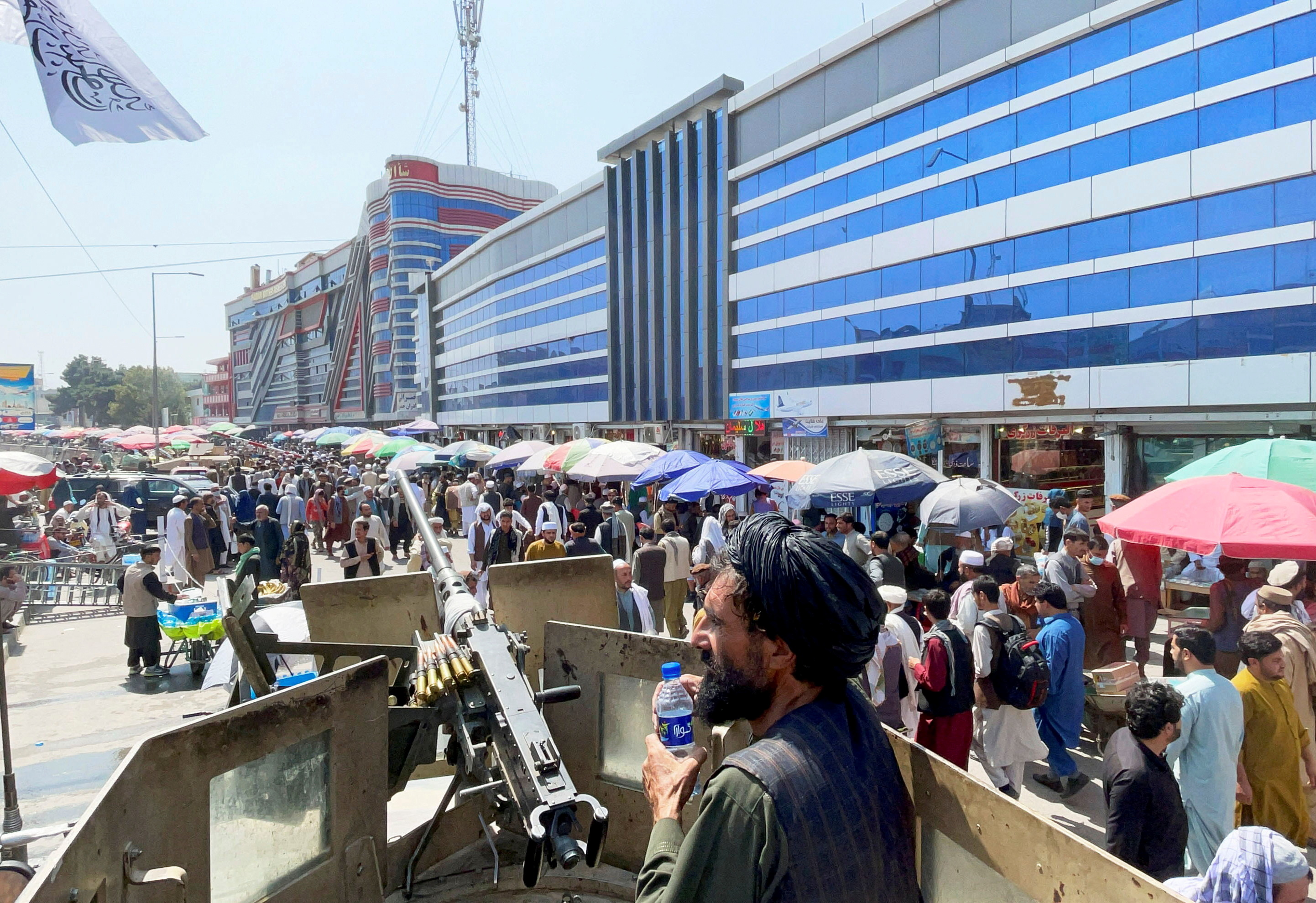Members of Taliban security forces stand guard among crowds