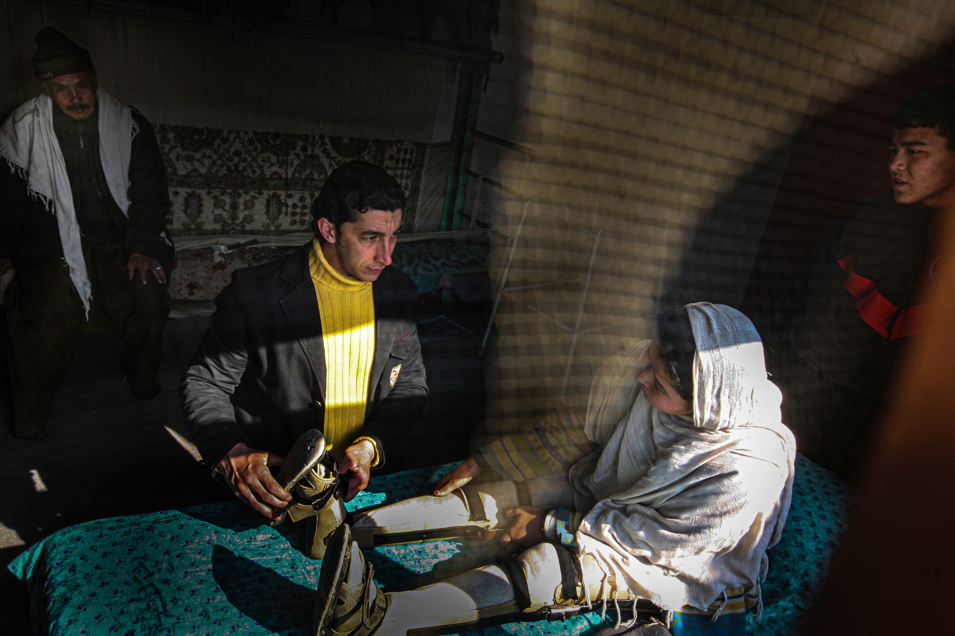 Bashir, an Afghan physiotherapist, treats a patient with a prosthetic limb during a house visit in Kabul [Ricardo Garcia Vilanova]