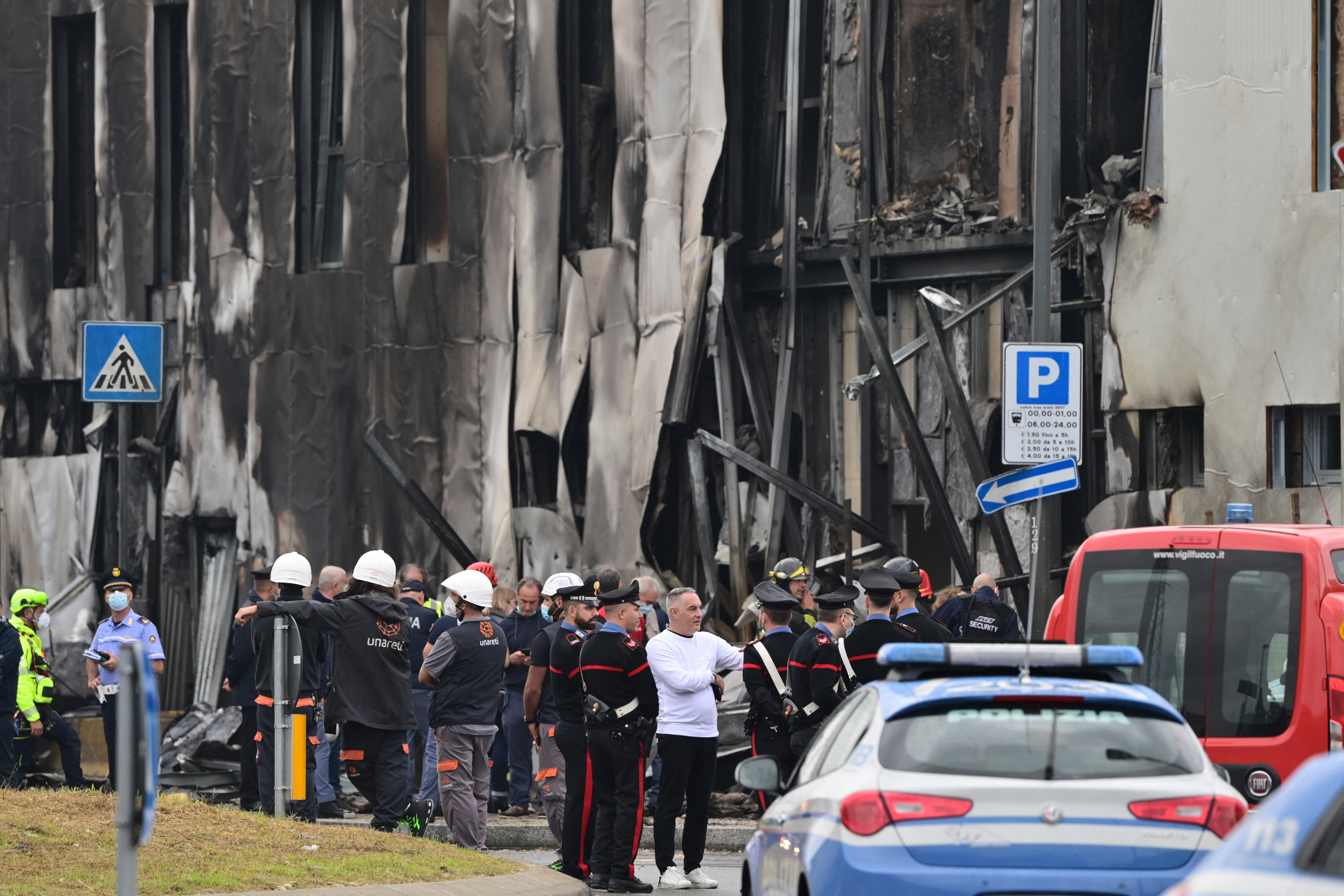 Police and rescue teams at a building where a small plane crashed in Milan suburb San Donato, October 3