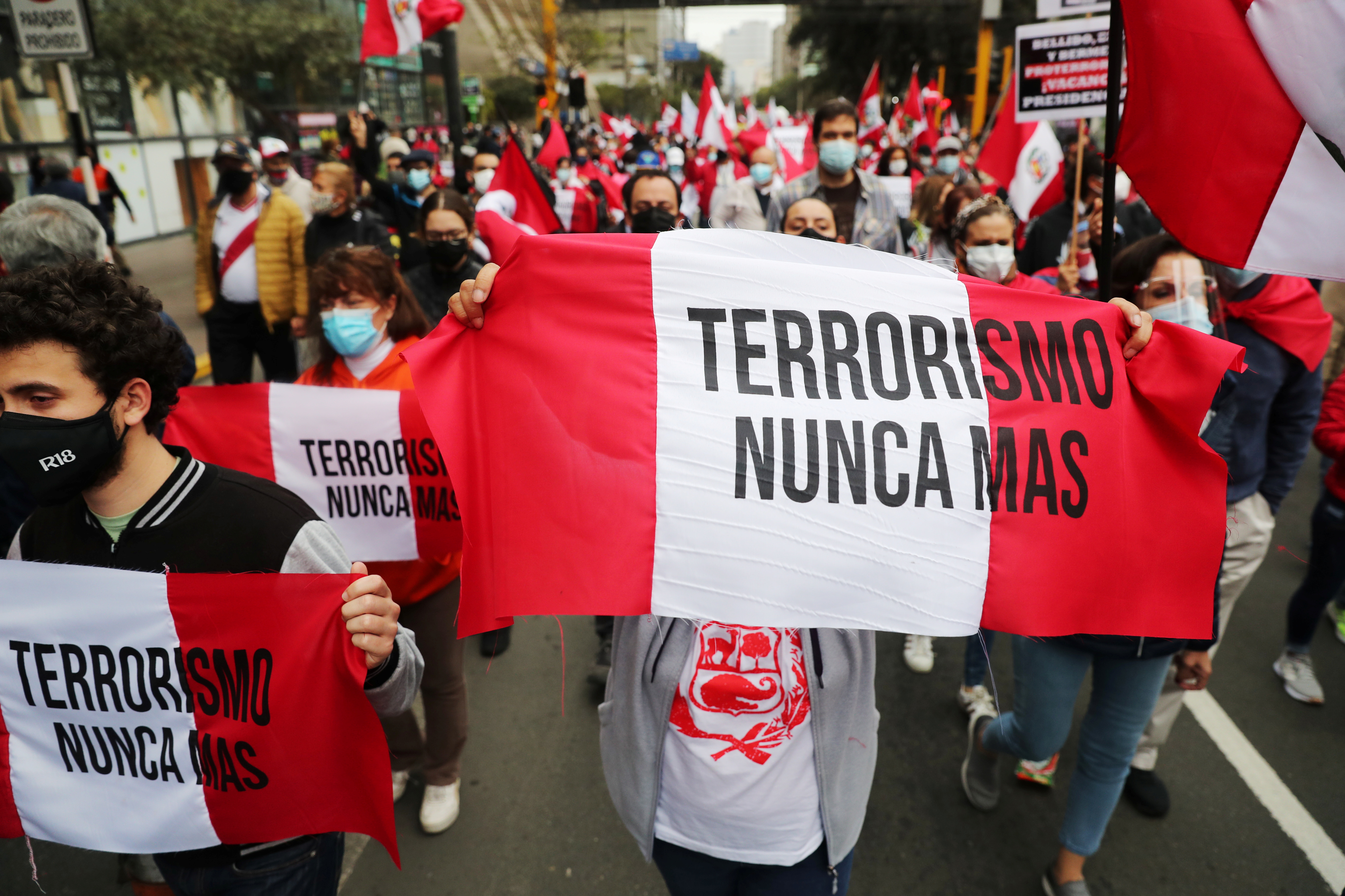 People holding banners reading 'Terrorism never again' gather to commemorate the 29th anniversary of the capture of Abimael Guzman, founder of Shining Path, in Lima, Peru on September 12, 2021 [Sebastian Castaneda/Reuters]