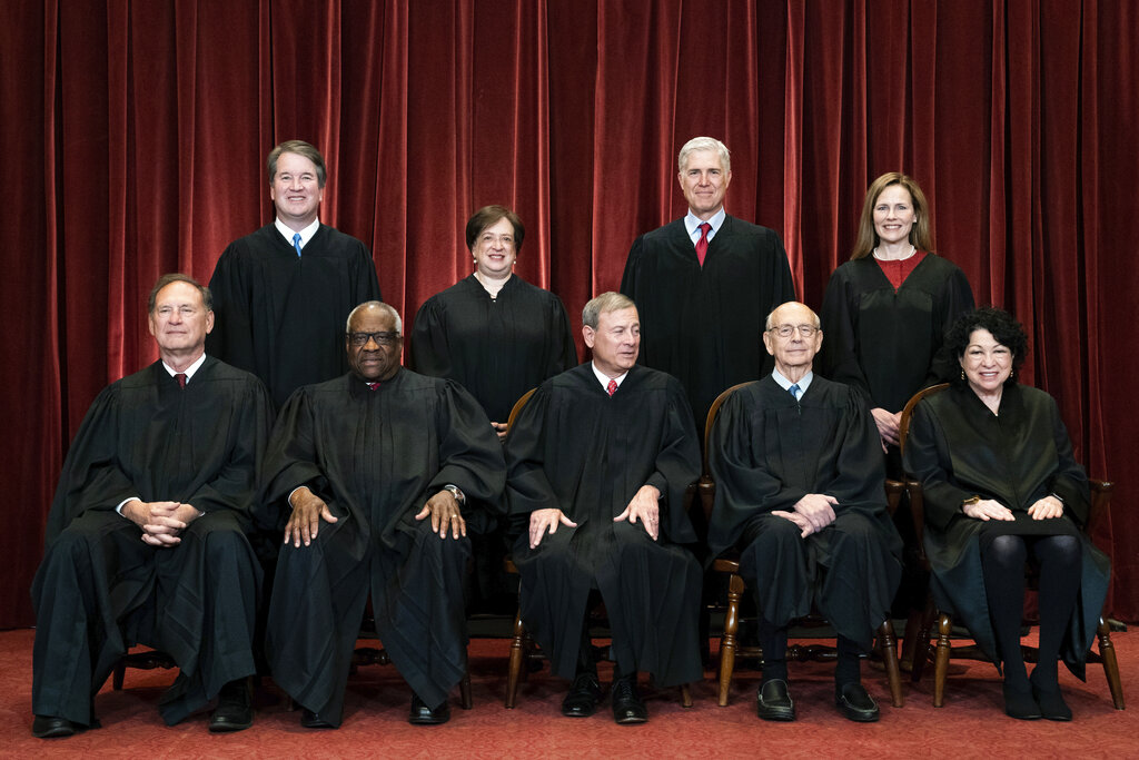 The nine justices of the Supreme Court, dressed in formal black robes, pose for a group photo at the Supreme Court in Washington, DC.