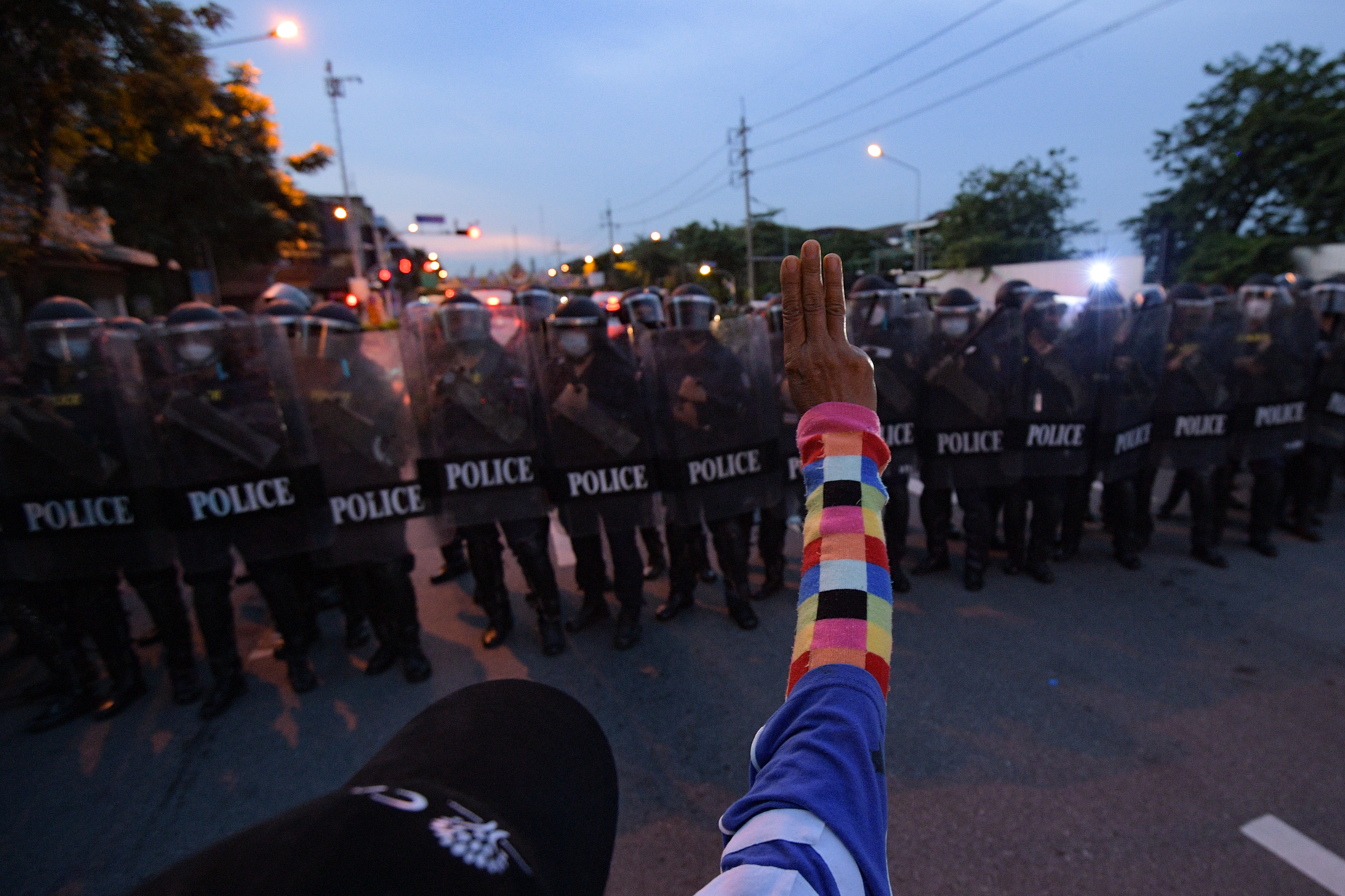 An anti-government protester holds up a three-finger salute in front of a riot police line during a protest near the Thai Government House in Bangkok on September 28 in Bangkok [Vachira Vachira/NurPhoto via Getty Images]
