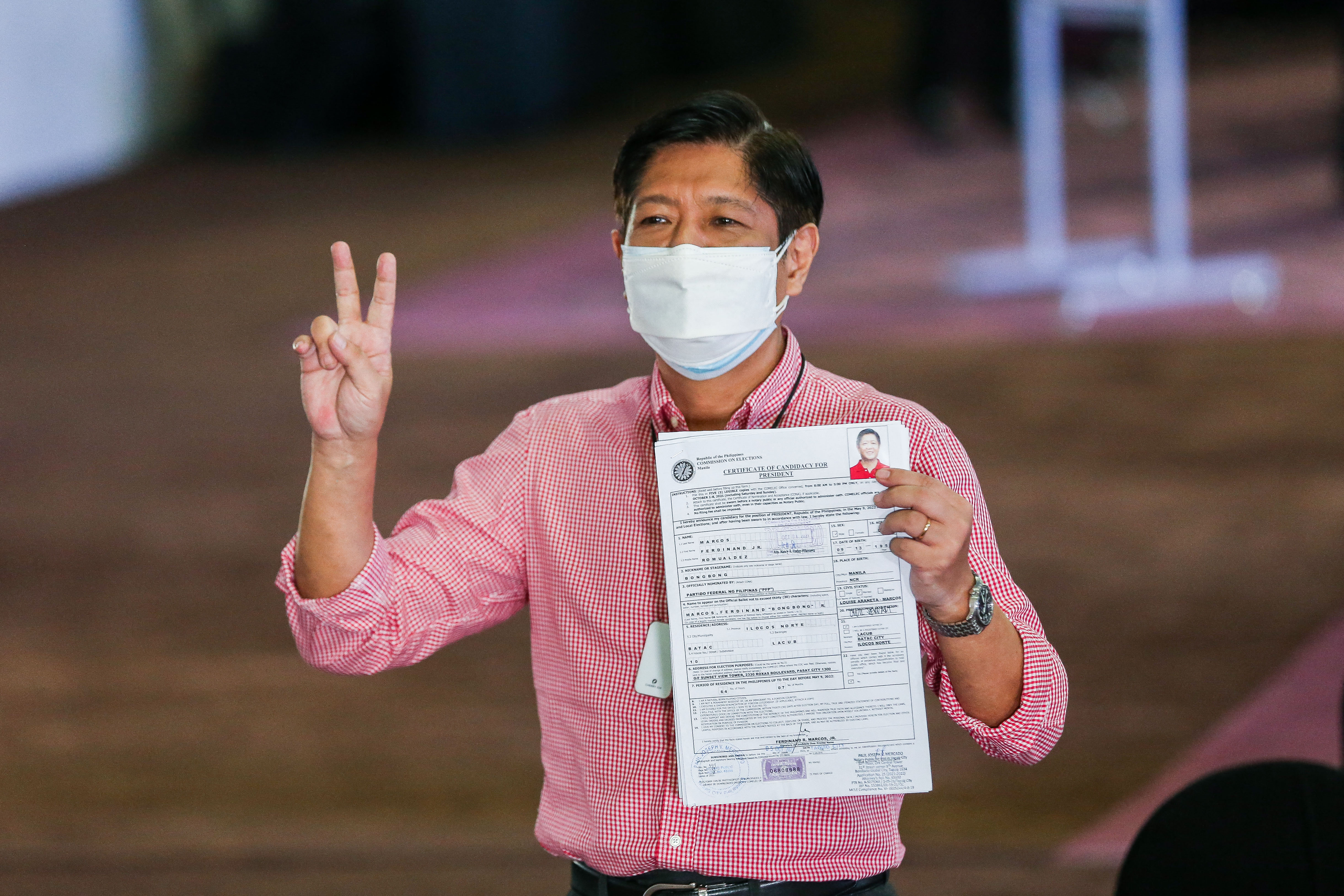 Son of former dictator Ferdinand Marcos, Ferdinand 'Bongbong' Marcos Jr, gestures after filing his candidacy for the country's 2022 presidential race, at Sofitel Harbor Garden Tent in Pasay on October 6, 2021 [File: Rouelle Umali/AFP]