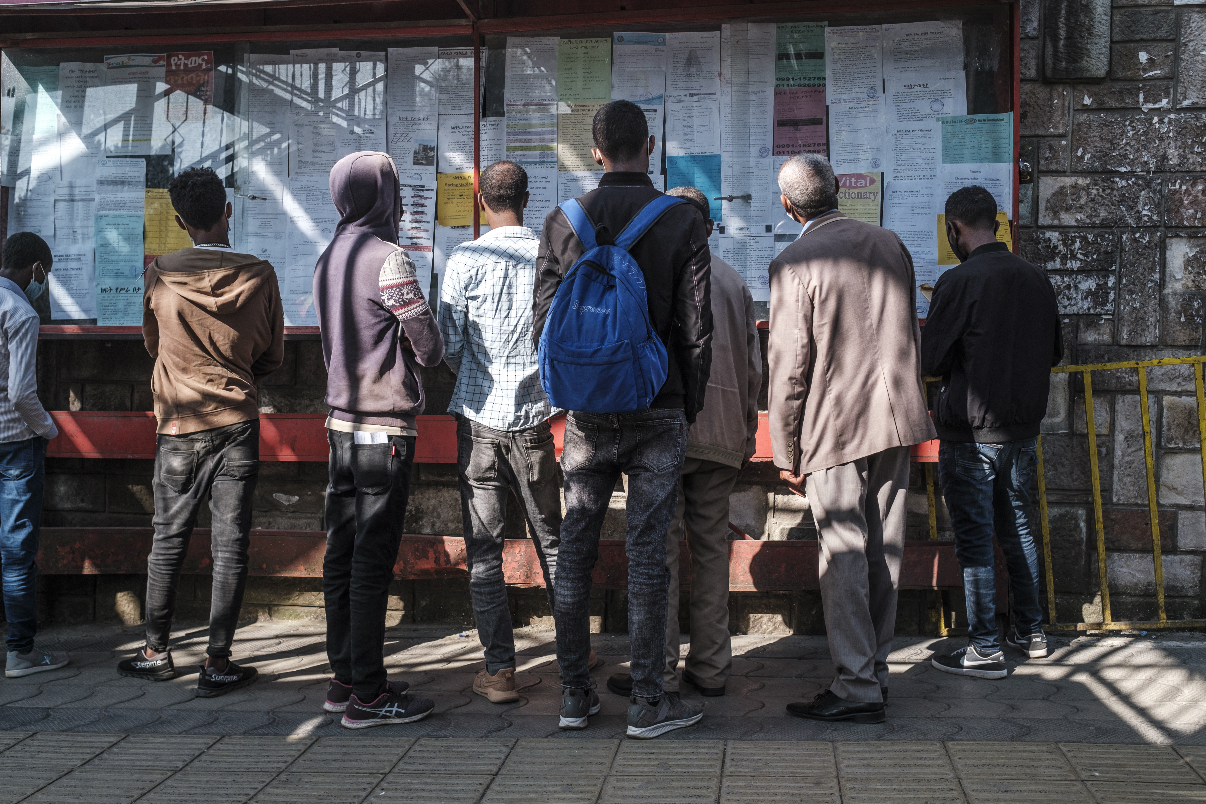 People look at a notice board with work offers in a downtown area of the city of Addis Ababa, Ethiopia, on November 3, 2021. [Eduardo Soteras/AFP]