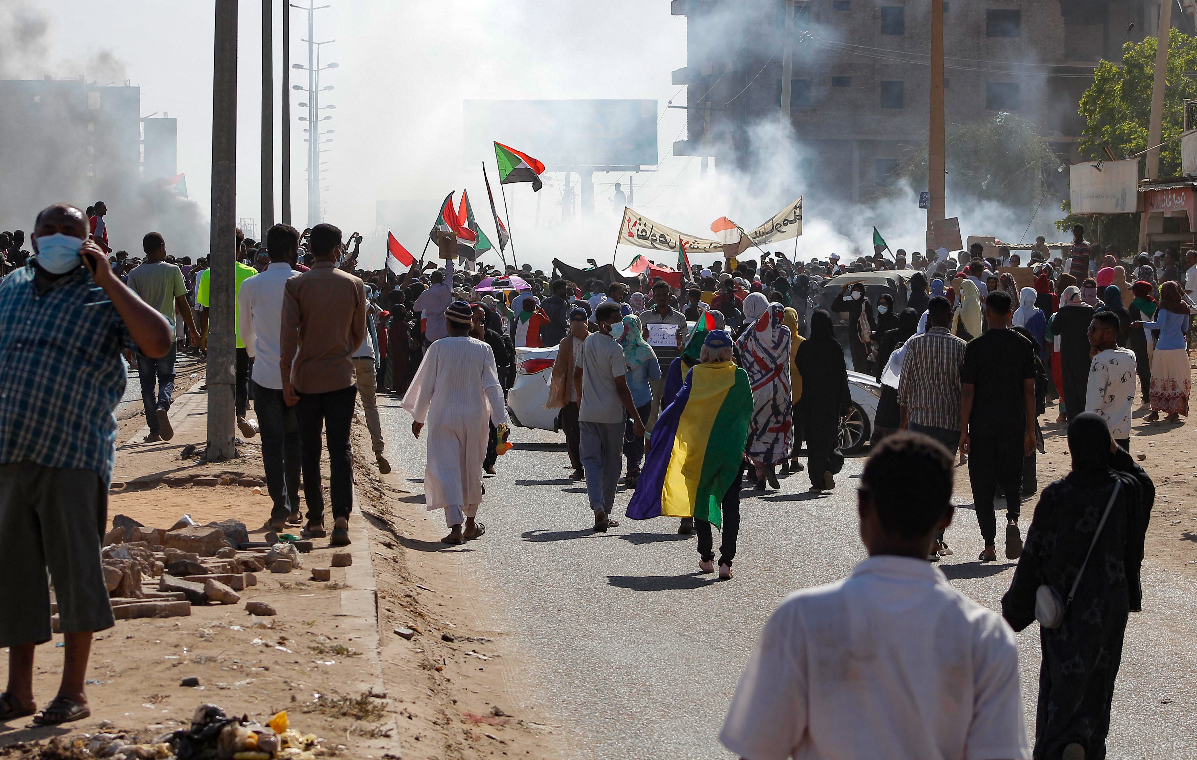 Sudanese opponents of the military coup wave national flags as they take part in a protest in the city of Khartoum North near the capital [AFP]